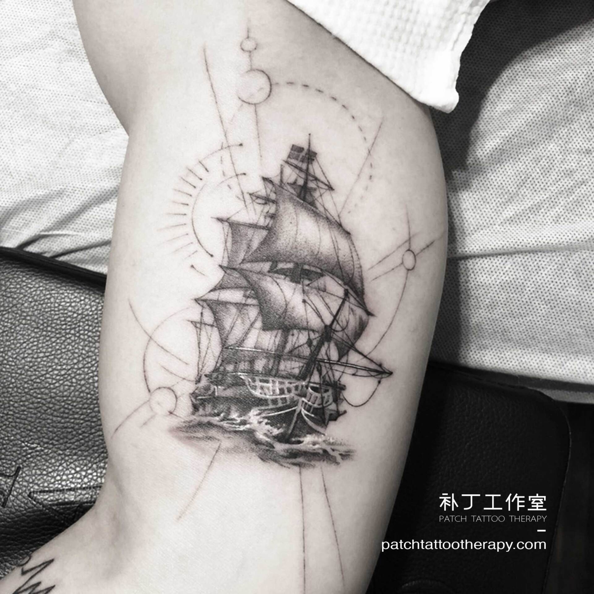 Inner arm ship tattoo in geometric style designed by Jingxi Gu at Patch Tattoo Therapy