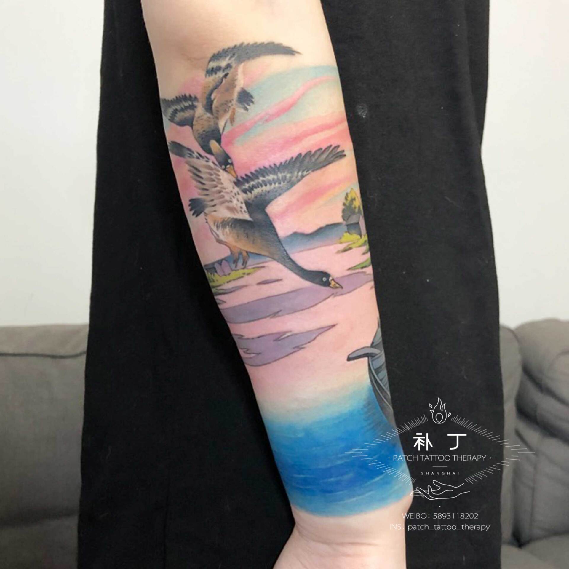Forearm sleeve tattoo of a peaceful scene featuring a boat, lake, ducks, and rustic buildings in Japanese styled color designed by Jingxi Gu at Patch Tattoo Therapy - angle 1