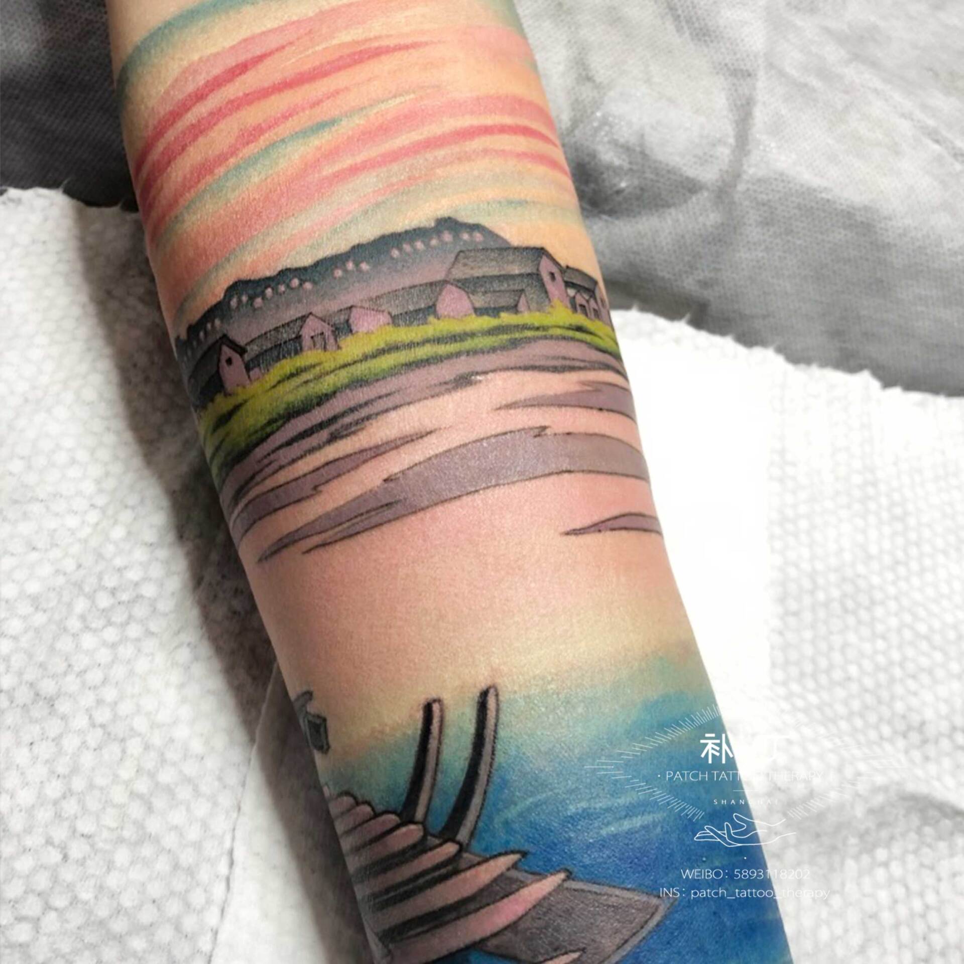Forearm sleeve tattoo of a peaceful scene featuring a boat, lake, ducks, and rustic buildings in Japanese styled color designed by Jingxi Gu at Patch Tattoo Therapy - angle 2
