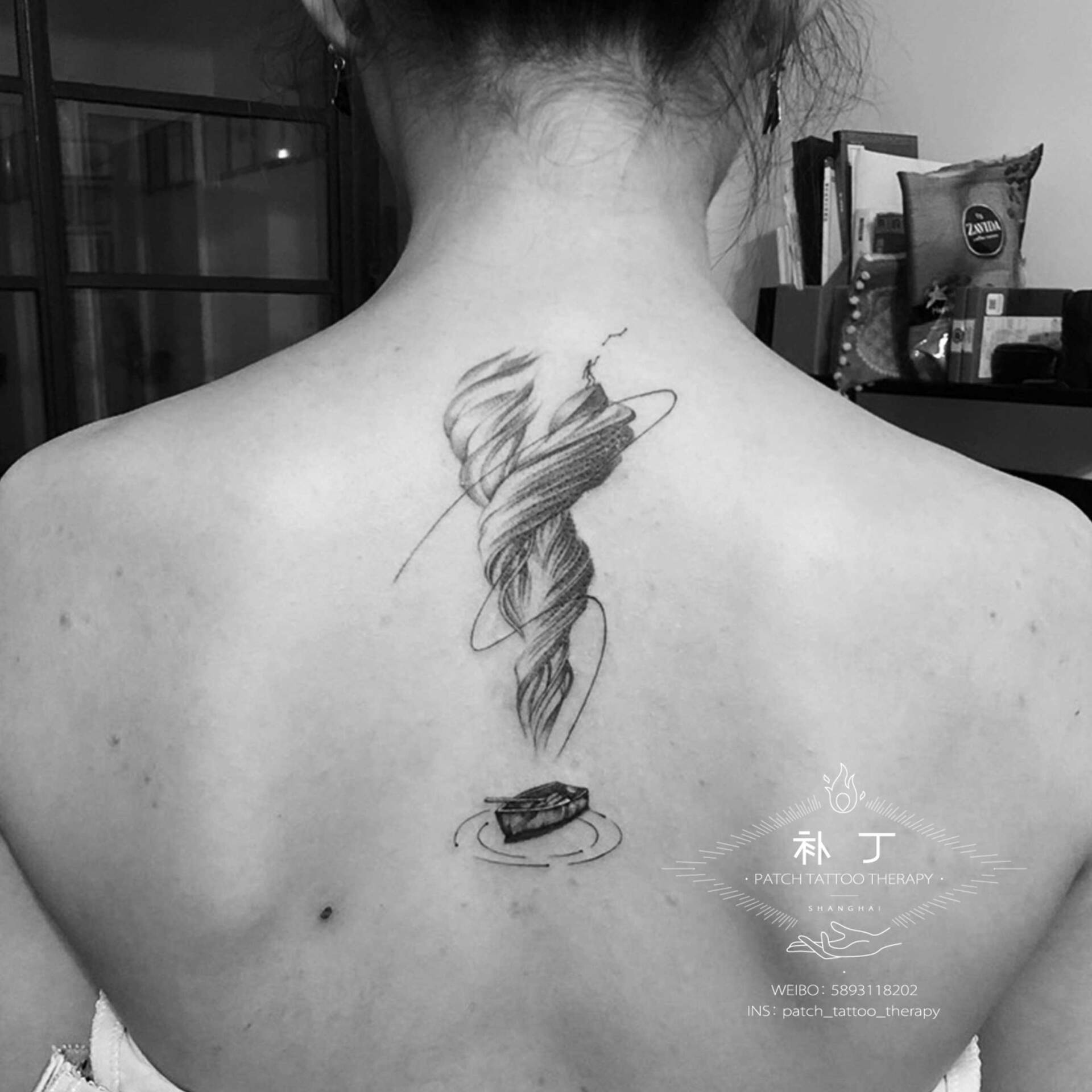 Back tattoo of a small man spun up from a rowing boat through a tornado in geometric style designed by Jingxi Gu at Patch Tattoo Therapy