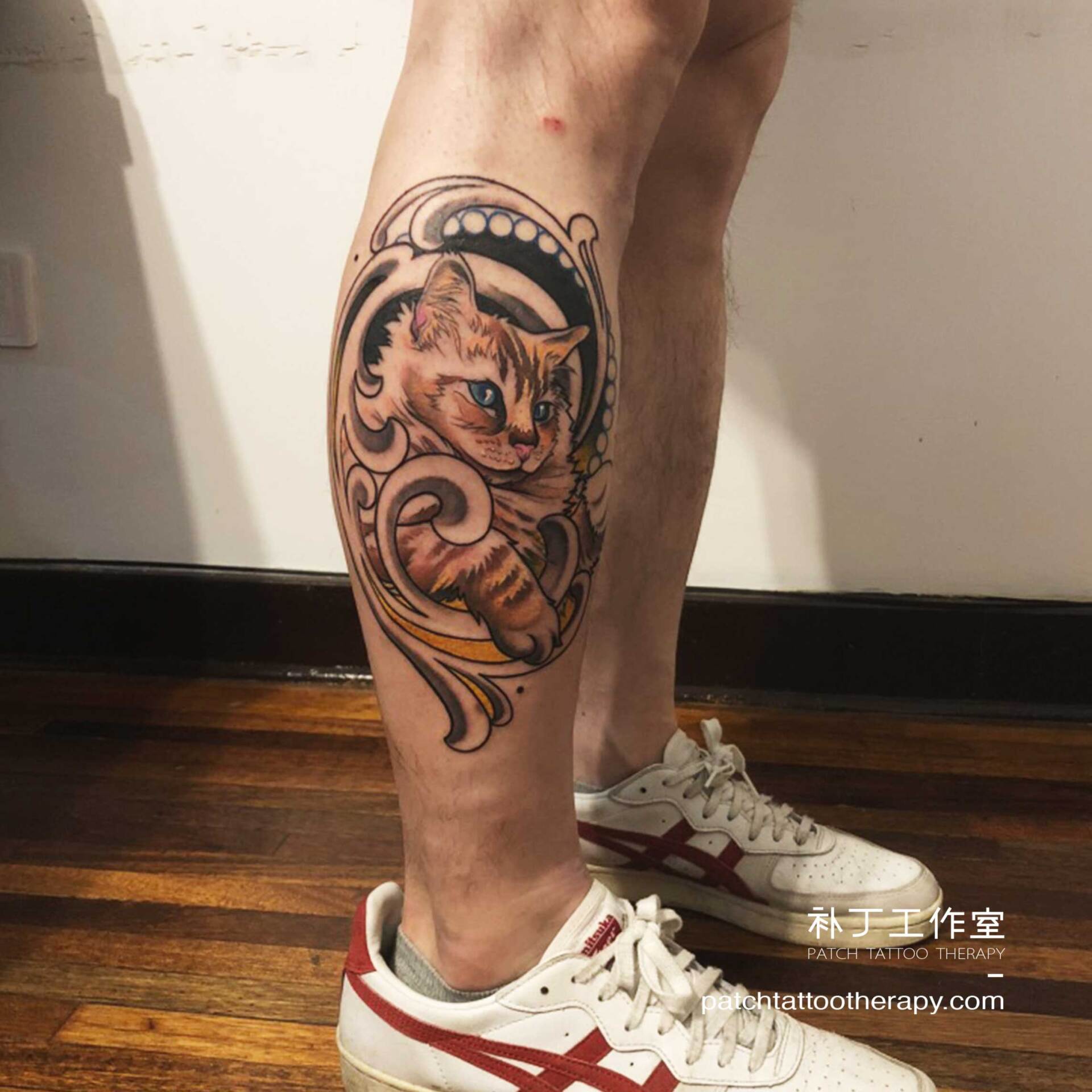 Outside calf tattoo of a cat in a colorful asian style designed by Jingxi Gu at Patch Tattoo Therapy
