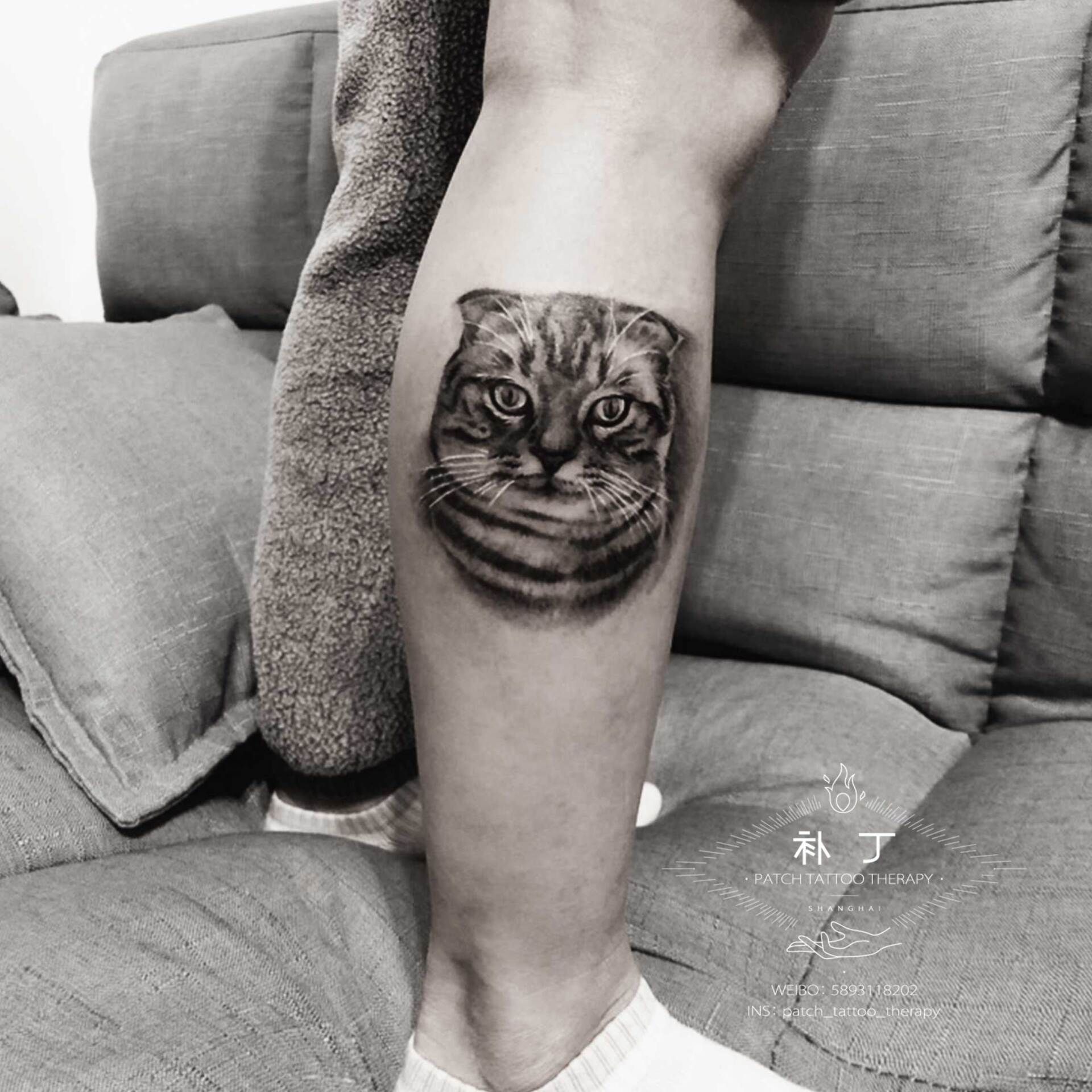 Outside calf portrait tattoo of a grumpy cat in black and grey realistic style designed by Jingxi Gu at Patch Tattoo Therapy