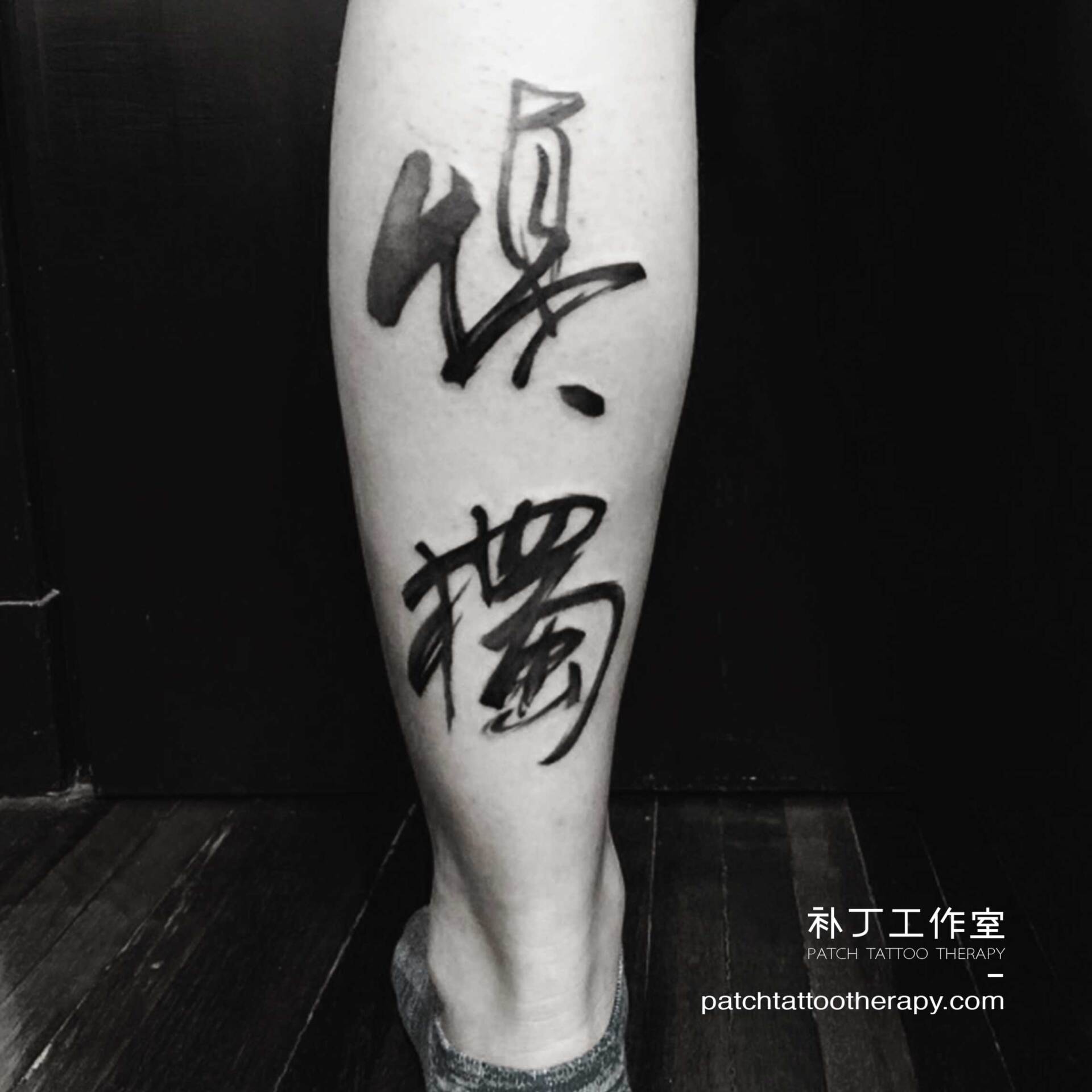 Back calf tattoo of Chinese letters in paintbrush calligraphy style designed by Jingxi Gu at Patch Tattoo Therapy - angle 1