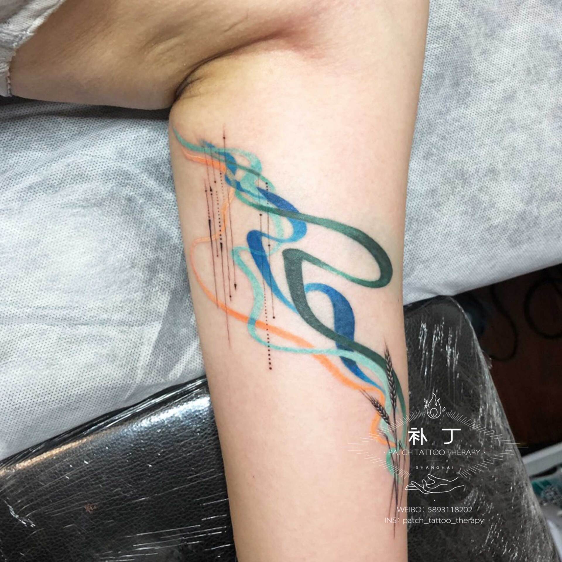 Inner arm tattoo of wheat with playful colored smoke and geometric shapes done designed by Jingxi Gu at Patch Tattoo Therapy - angle 3