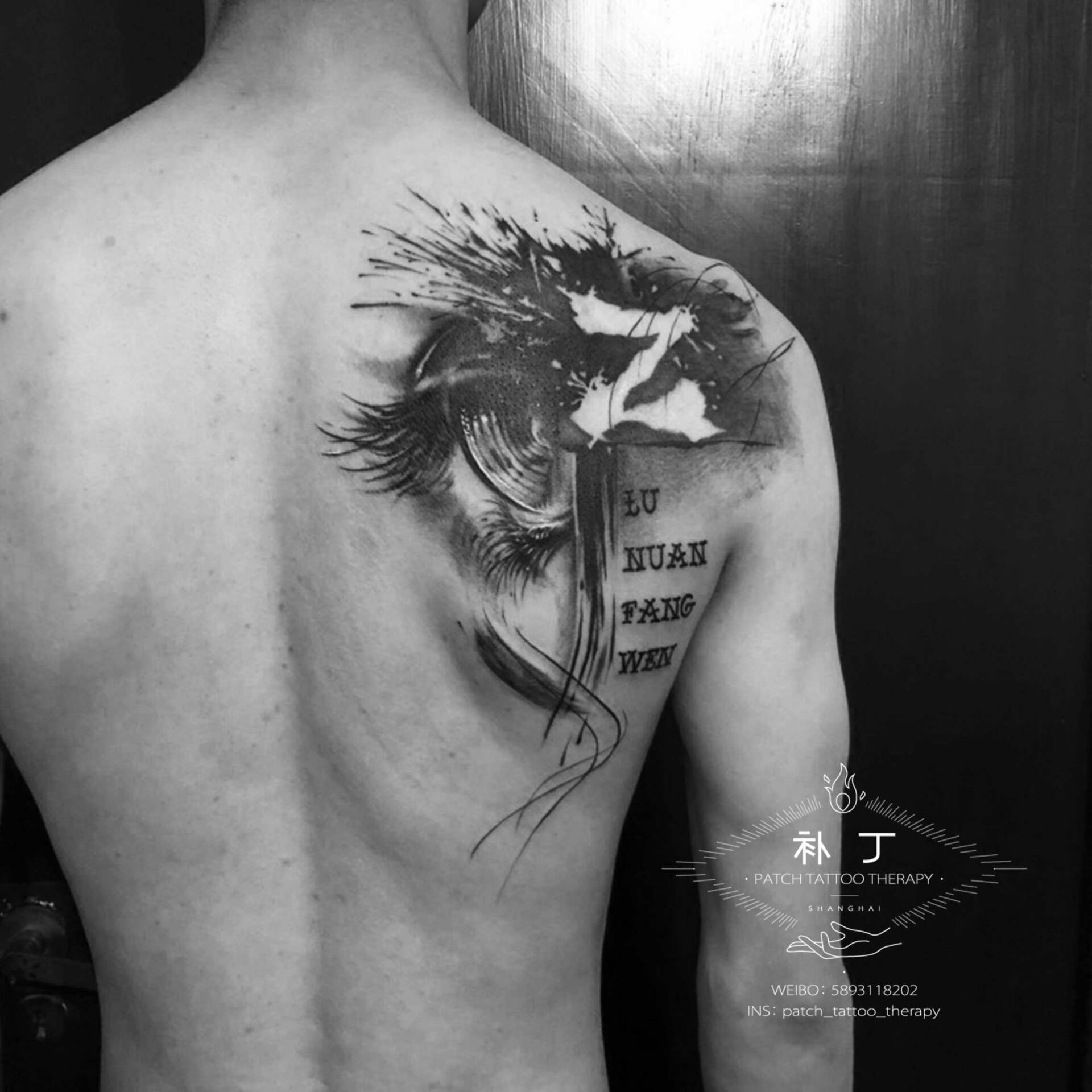 Back tattoo of an eye and text in splashy abstract style designed by Jingxi Gu at Patch Tattoo Therapy