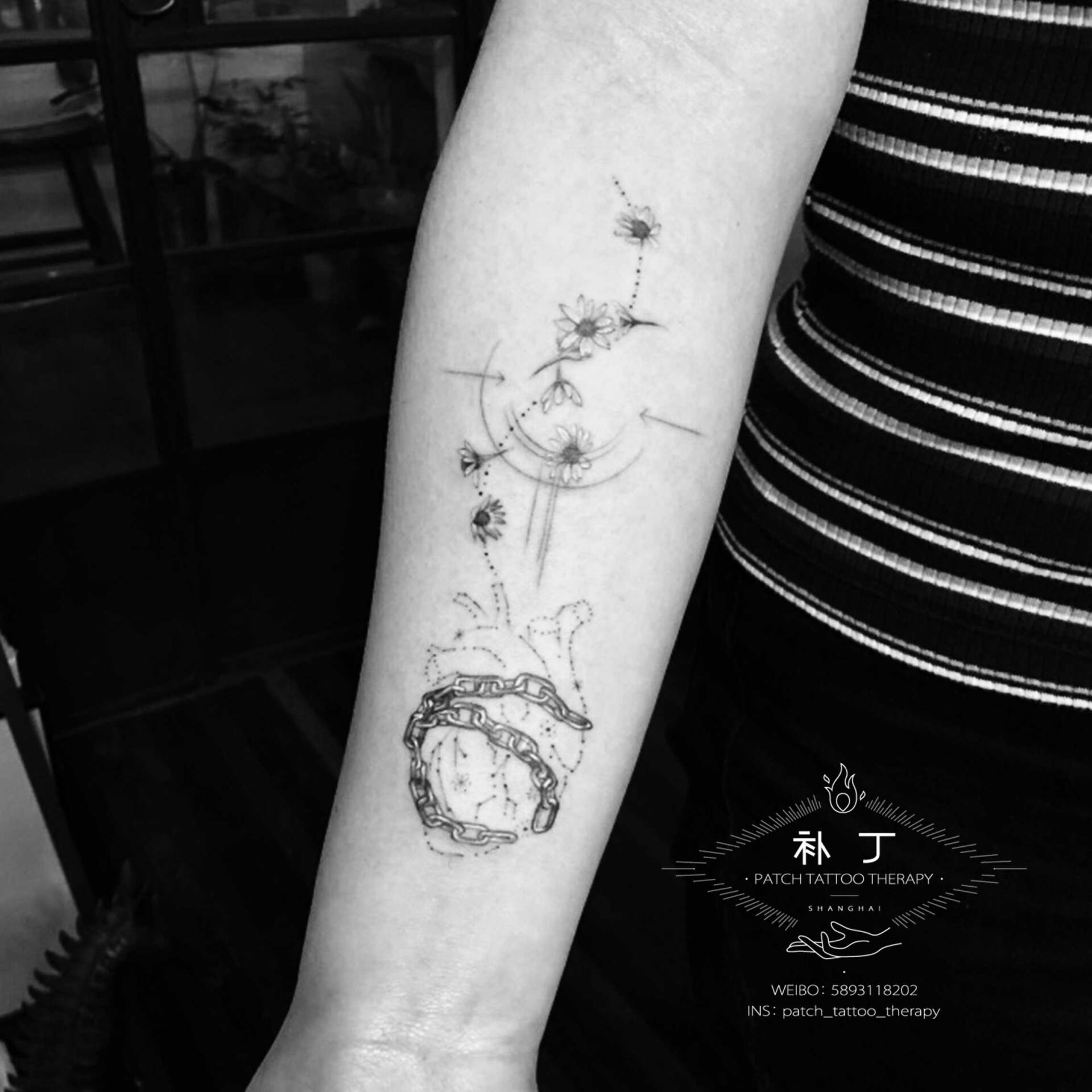 Inner forearm tattoo of a star pattern heart in chains released and escaped into flowers in geometric style designed by Jingxi Gu at Patch Tattoo Therapy