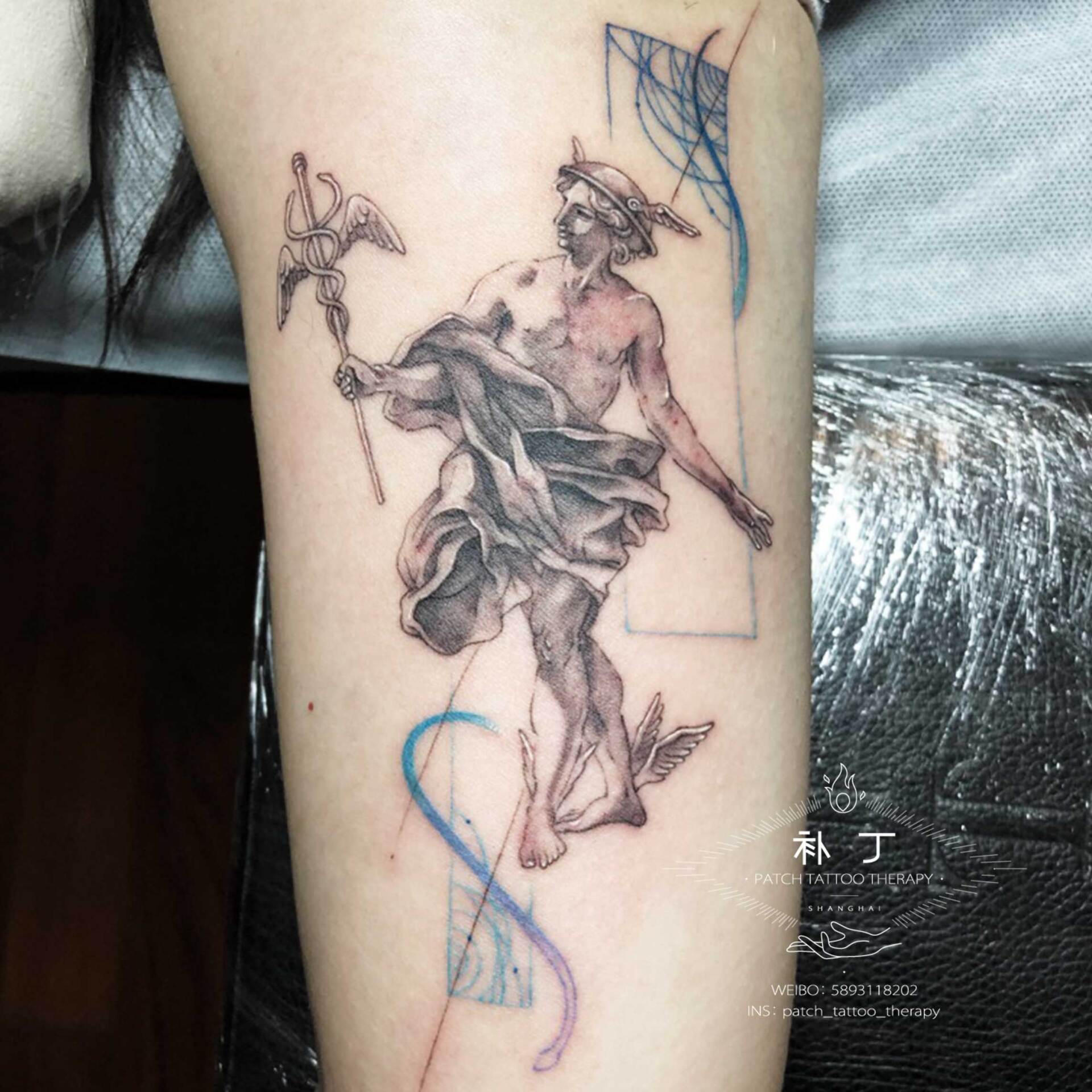 Inner arm tattoo of Hermes in a graceful pose done in geometric style with some colors designed by Jingxi Gu at Patch Tattoo Therapy - angle 1
