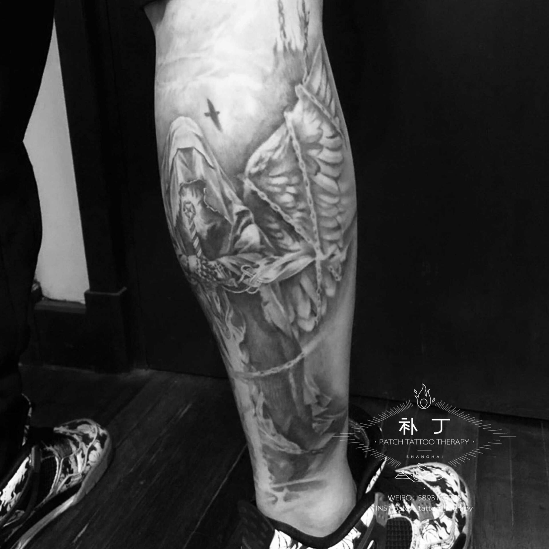 Back calf tattoo of a hooded warrior in black and grey realistic style designed by Jingxi Gu at Patch Tattoo Therapy - angle 3