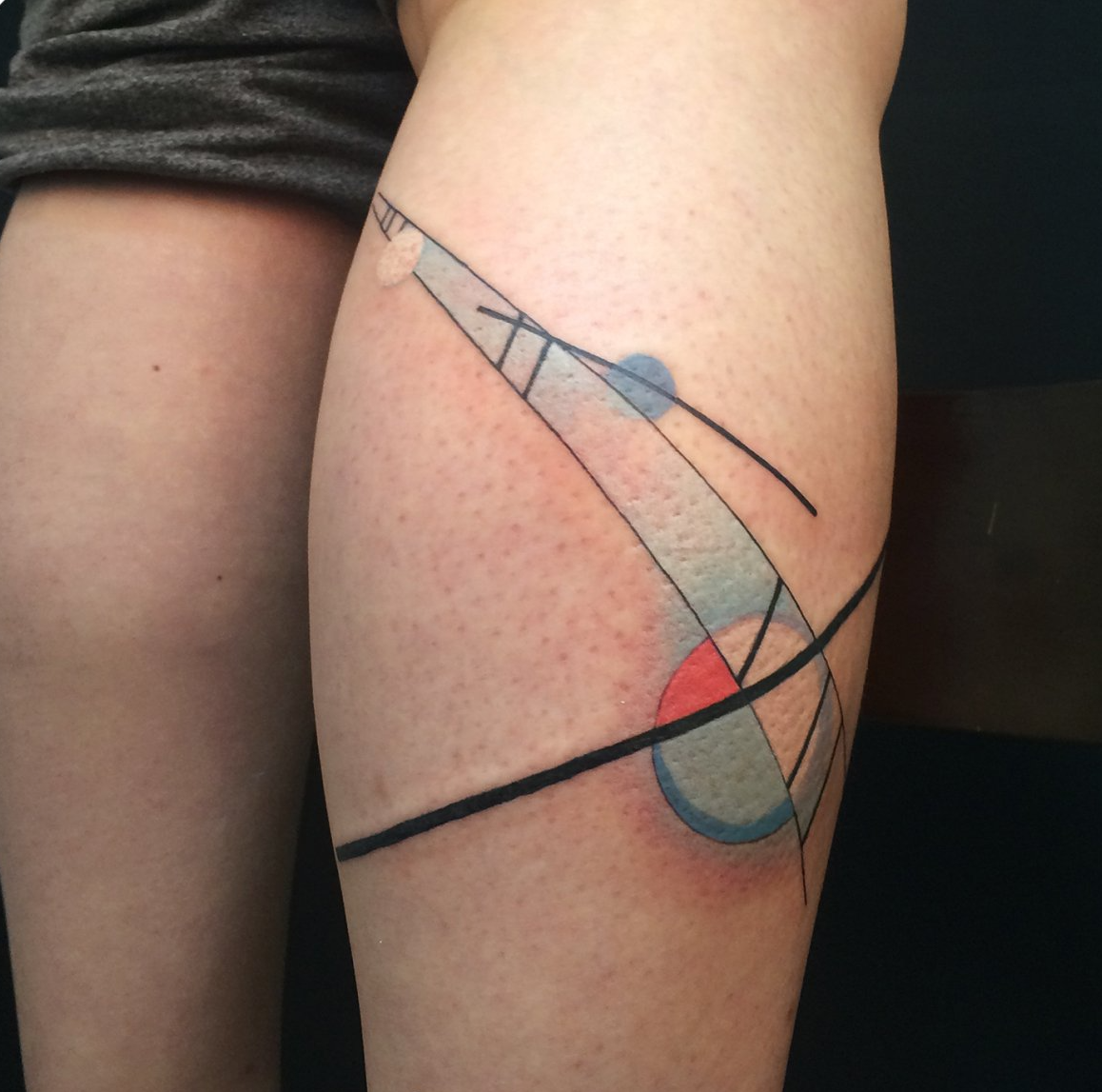Outside calf leg tattoo of geometric shapes in colored Kandinksy style designed by Jingxi Gu at Patch Tattoo Therapy