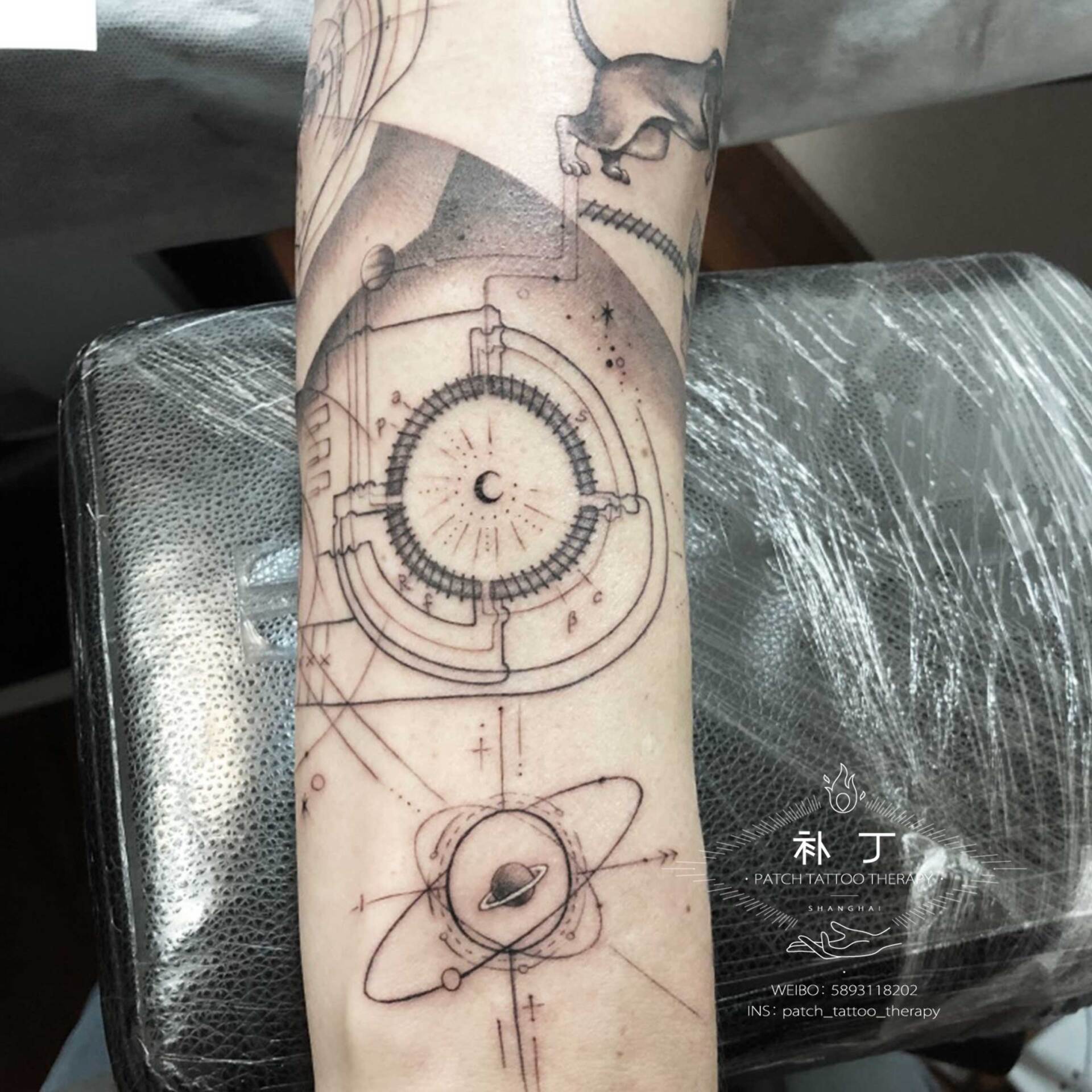 Full forearm sleeve tattoo featuring a space ship, a wife, planets, stars, a lion, an eye, nikota tesla elementes, and a satellite in geometric style designed by Jingxi Gu at Patch Tattoo Therapy - angle 4