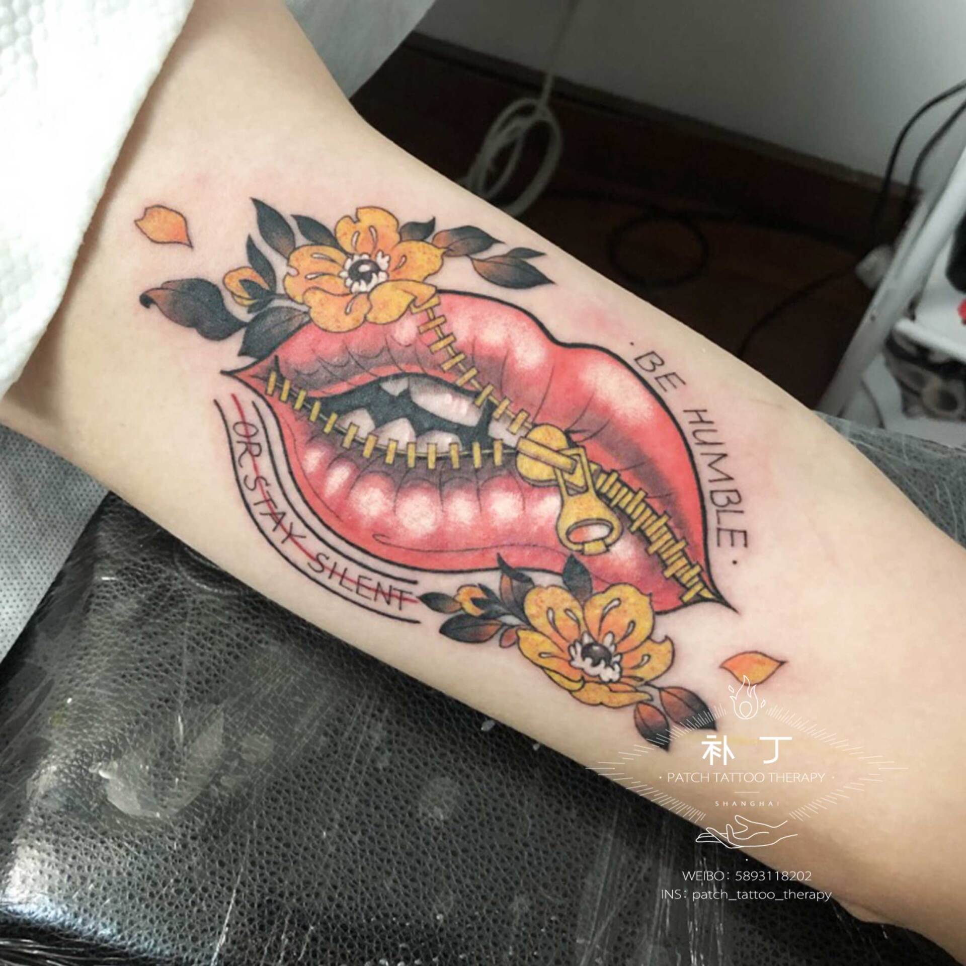 Inner arm tattoo of lips with zipper and flowers in traditional style designed by Jingxi Gu at Patch Tattoo Therapy