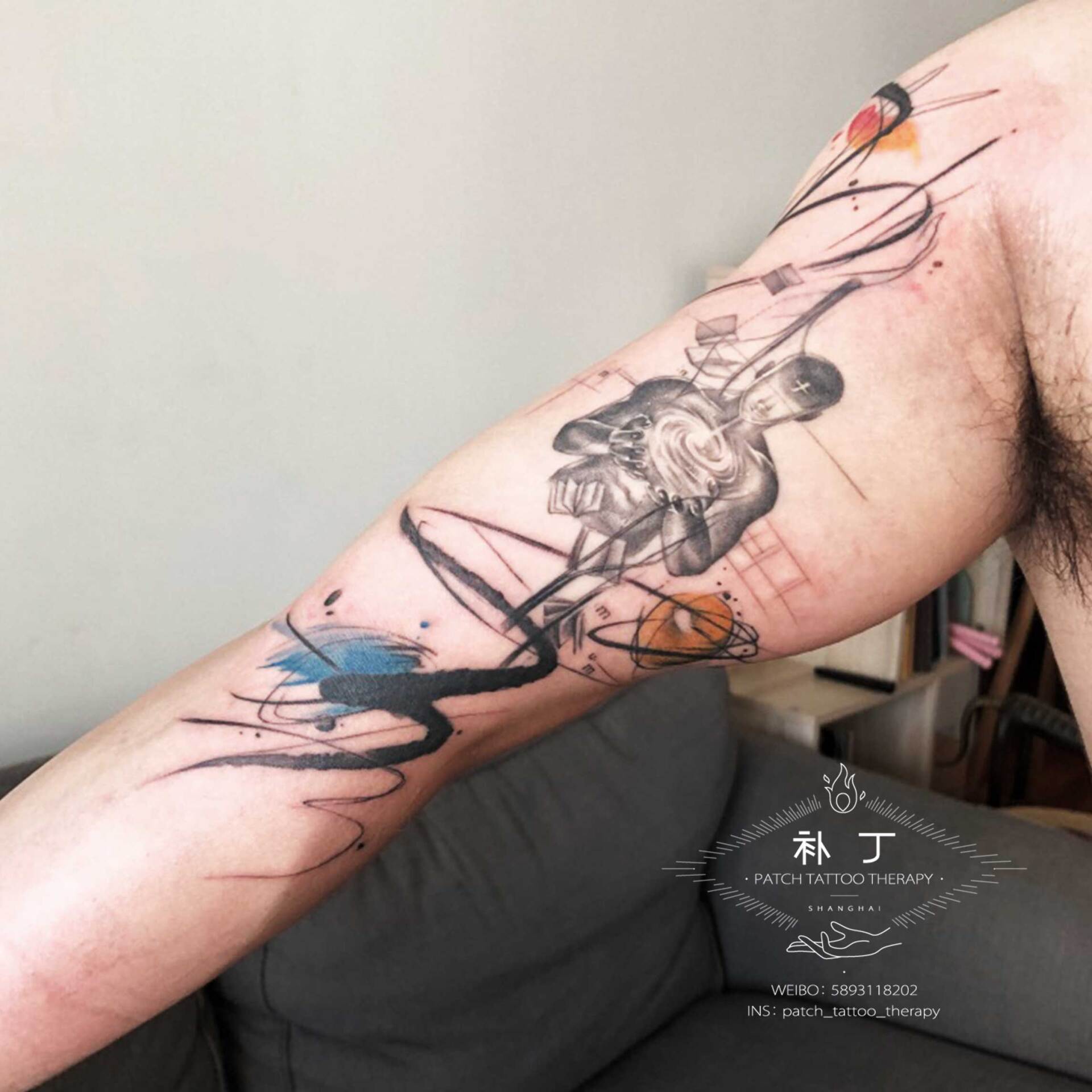 Arm tattoo of an astract universe man harnessing the power of books in a geometric watercolor hybrid style with some color designed by Jingxi Gu at Patch Tattoo Therapy - angle 1