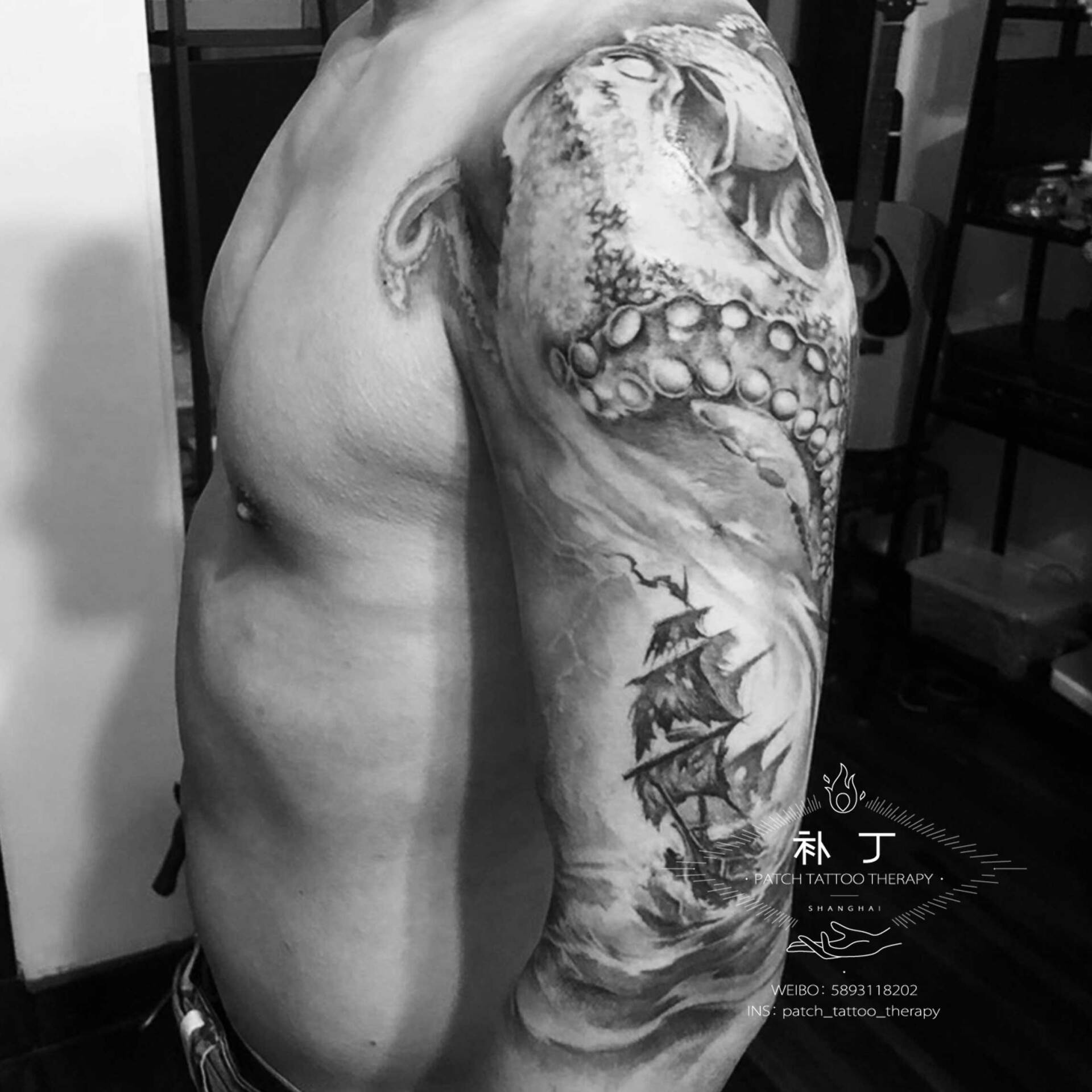 Half upper arm sleeve of an octopus, ship, and hammerhead sharks in black and grey realistic style designed by Jingxi Gu at Patch Tattoo Therapy - angle 3