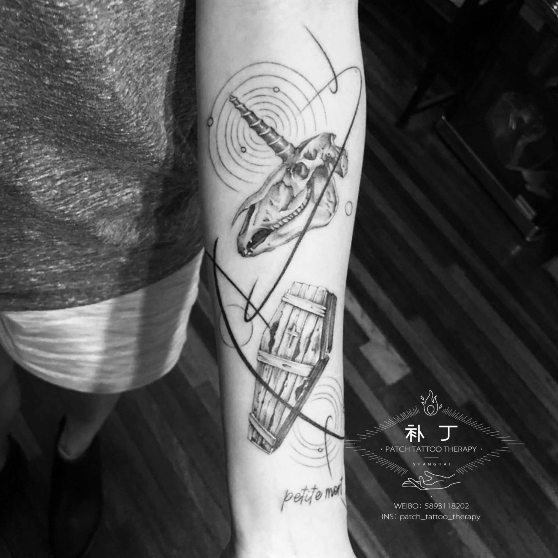 Inner forearm tattoo of a unicorn skull and a coffin in geometric style designed by Jingxi Gu at Patch Tattoo Therapy