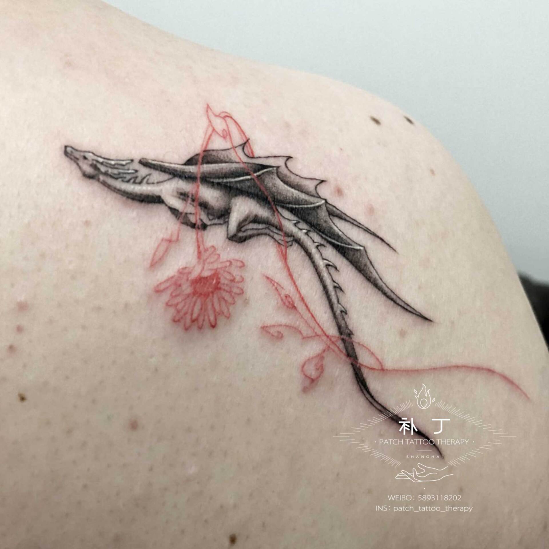 Back tattoo of a flying dragon wrapped around a red flower in geometric style designed by Jingxi Gu at Patch Tattoo Therapy - angle 2