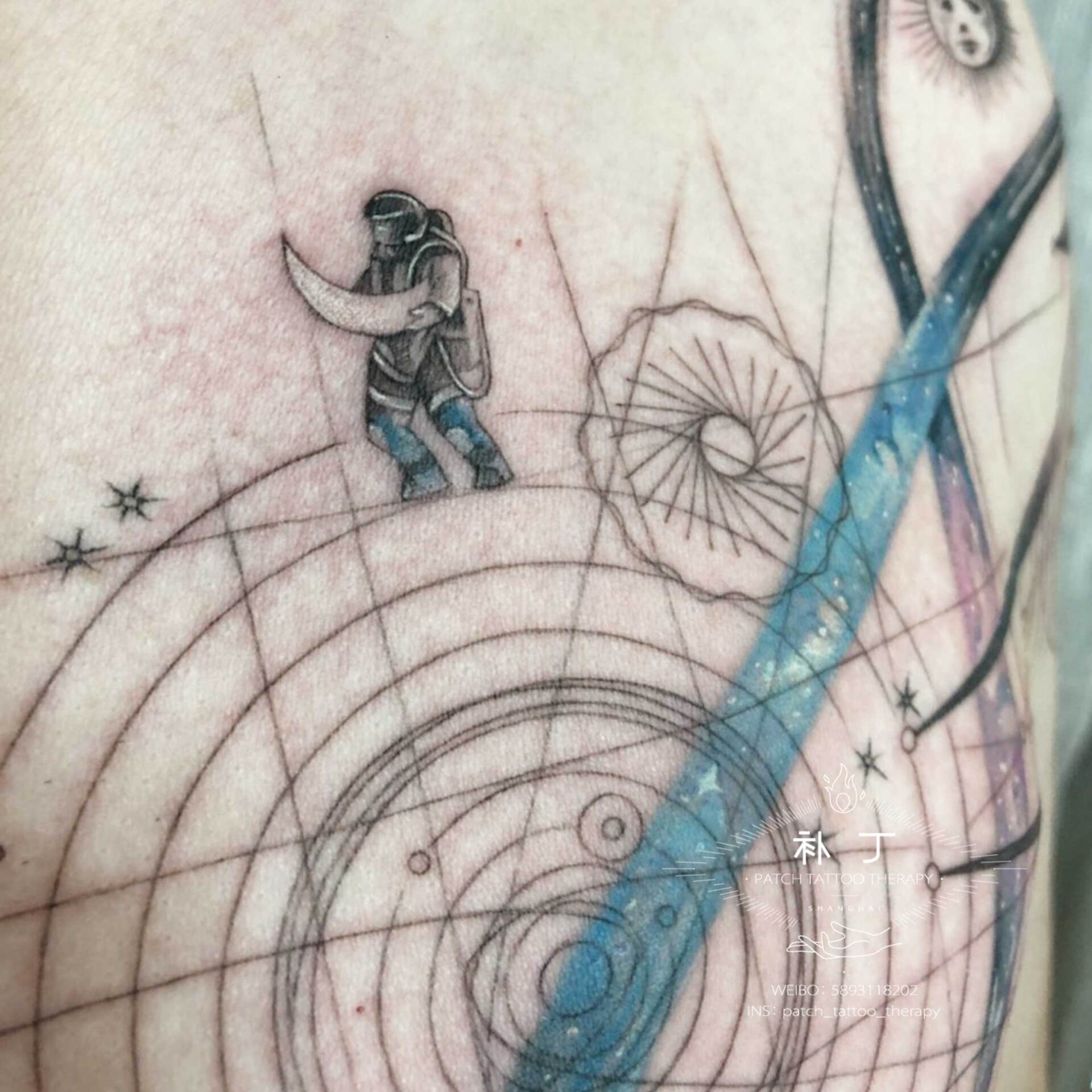 Shoulder and chest tattoo of a man holding a moon featuring the solar system, planets, the sun, and stars in geometric style designed by Jingxi Gu at Patch Tattoo Therapy - angle 3