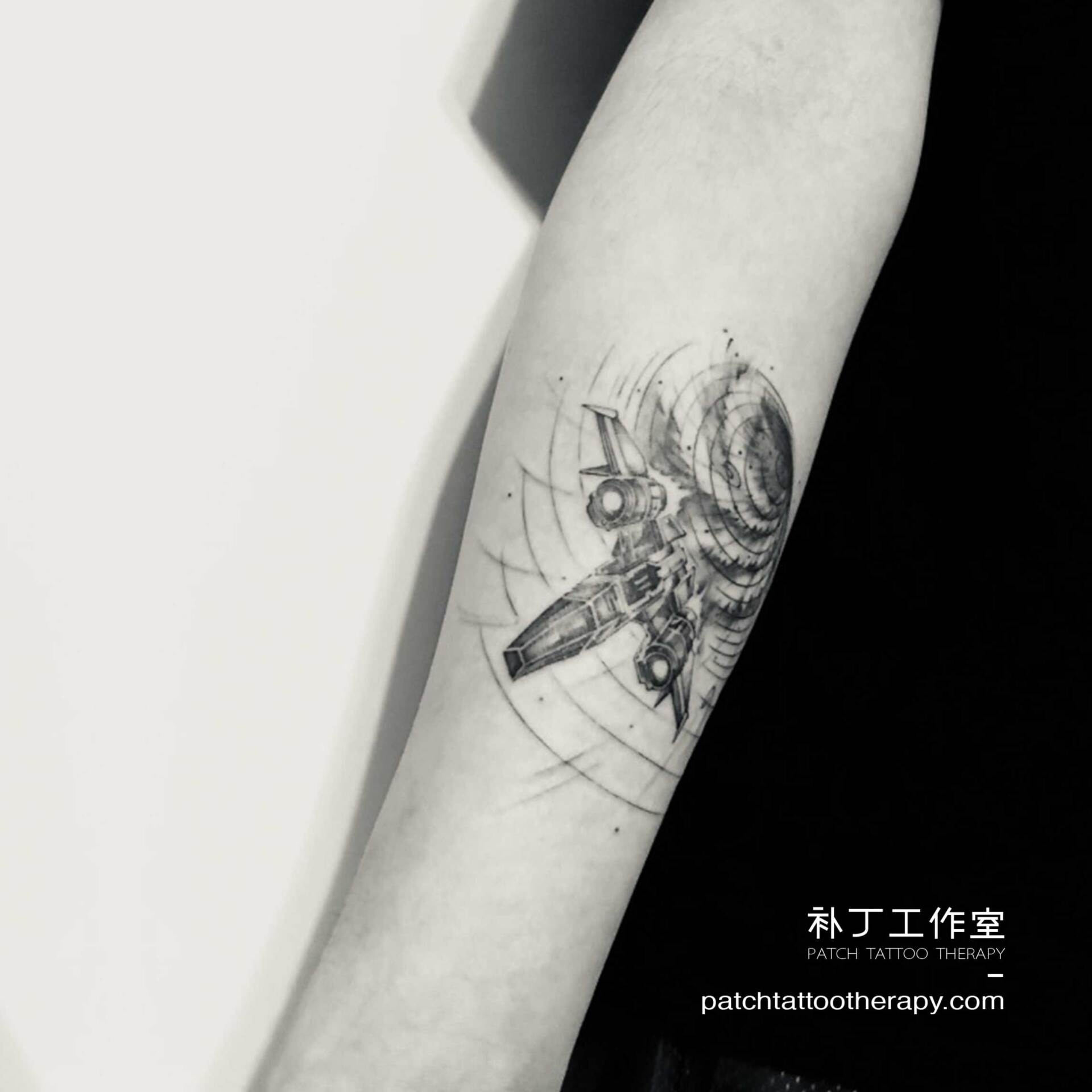 Inner forearm tattoo of a spaceship escaping a grid vortex hole in geometric style designed by Jingxi Gu at Patch Tattoo Therapy - angle 2