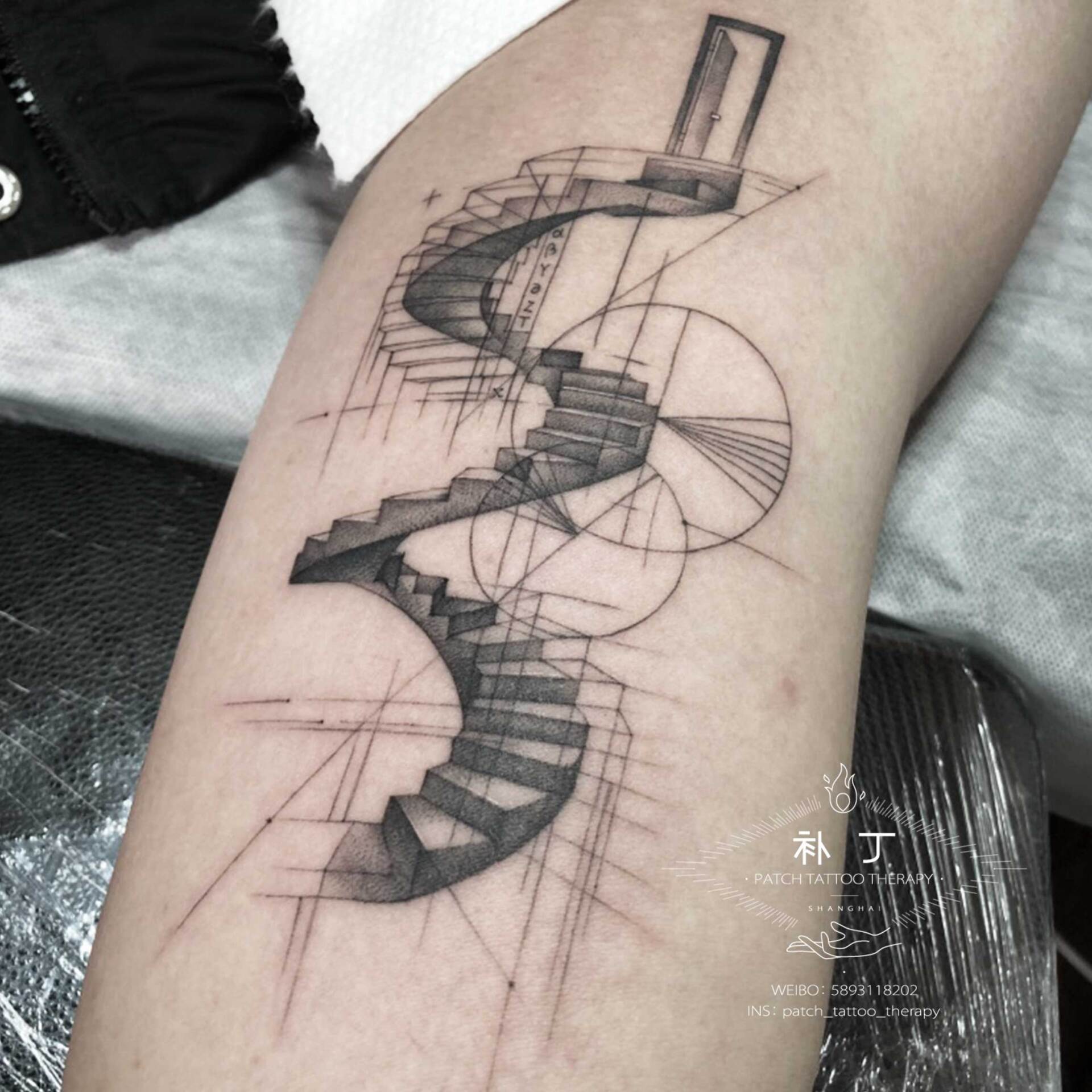 Inner arm tattoo of spiraling stairs leading up to a door in geometric style designed by Jingxi Gu at Patch Tattoo Therapy