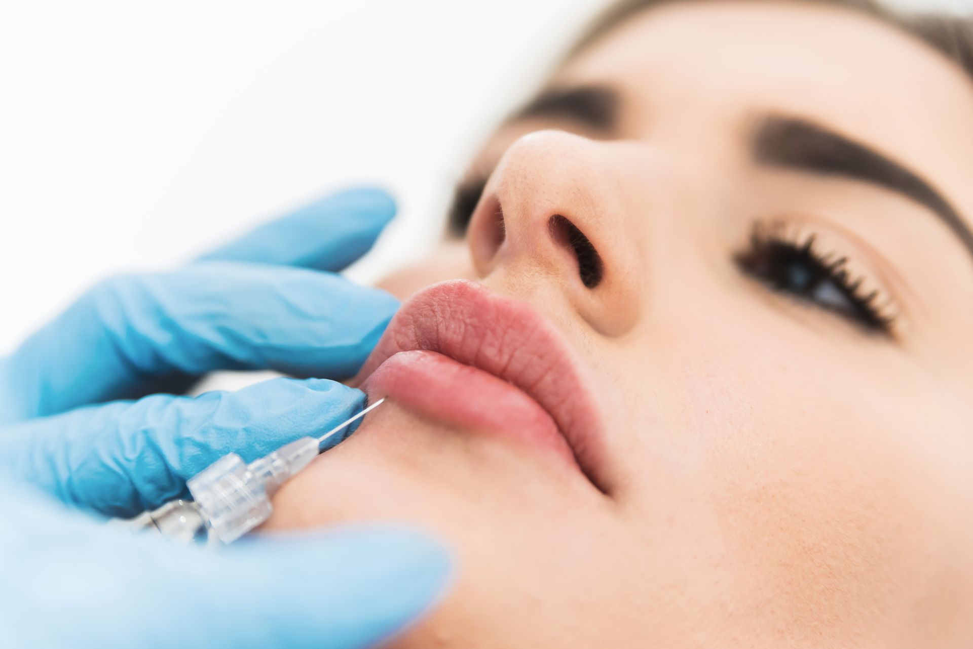 A man receiving a Botox injection in a clinic from an aesthetician.
