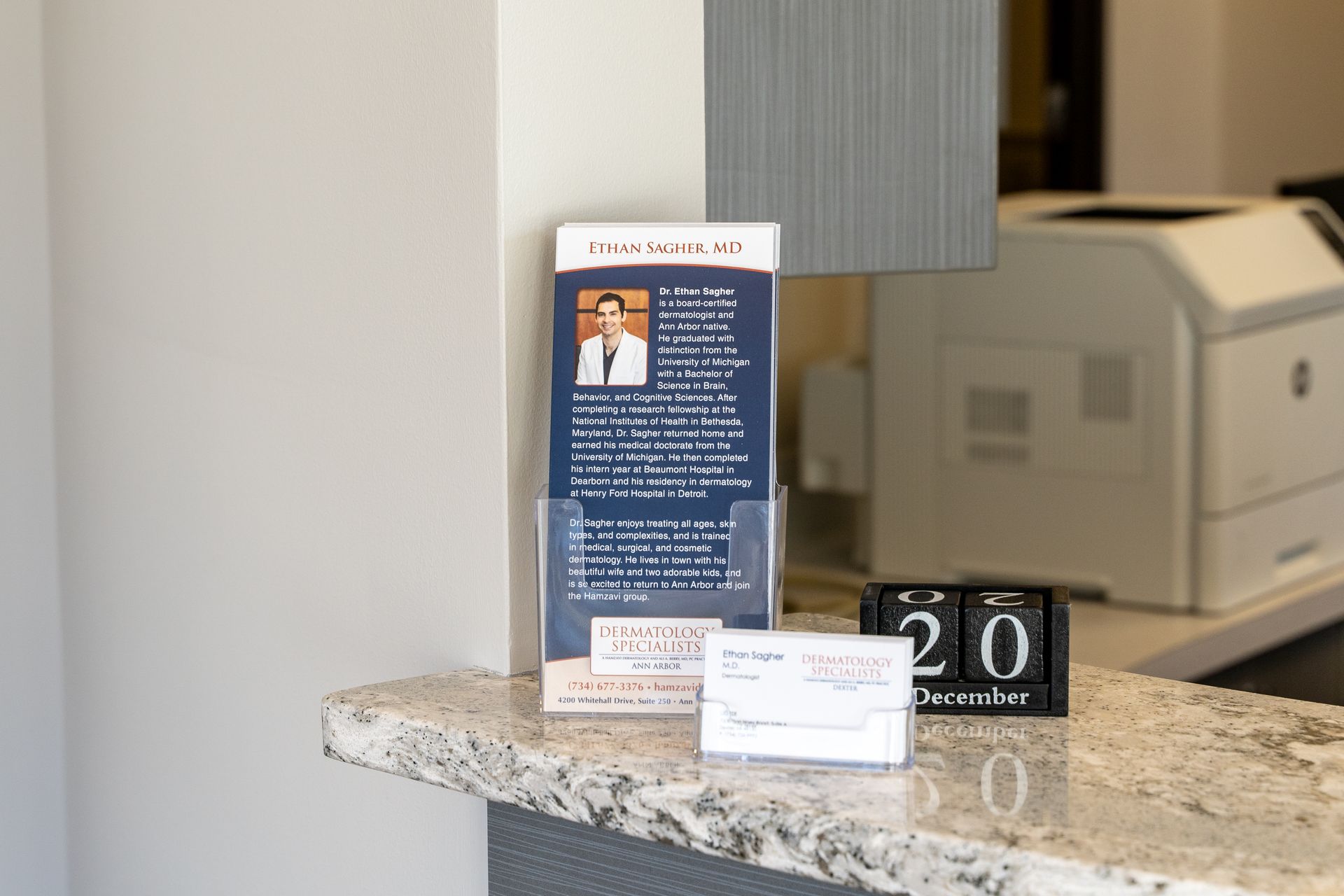 Reception desk with brochure, calendar, and printer.