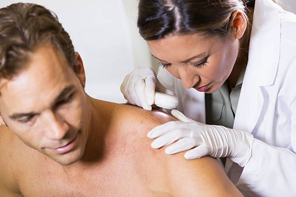 A Hamzavi Dermatology specialist performing a thorough skin exam in Chelsea, MI, emphasizing skin he