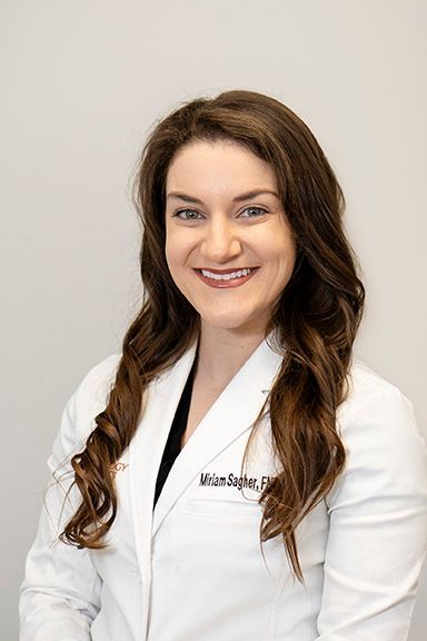 Woman in white lab coat, smiling, with dark hair, Dr. Miriam Seger.