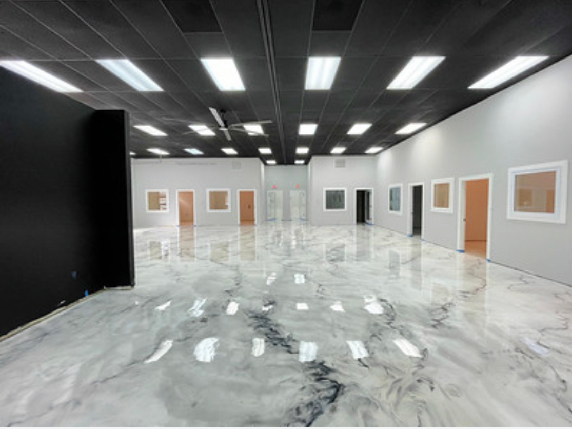 Shiny, reddish-brown epoxy floor with white veining in a room.