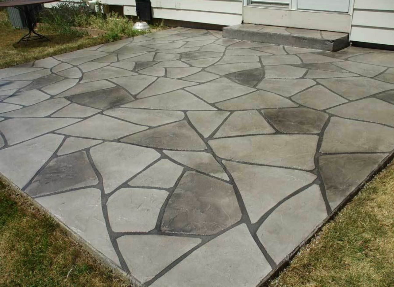 Concrete patio with gray and black stone-like pattern.