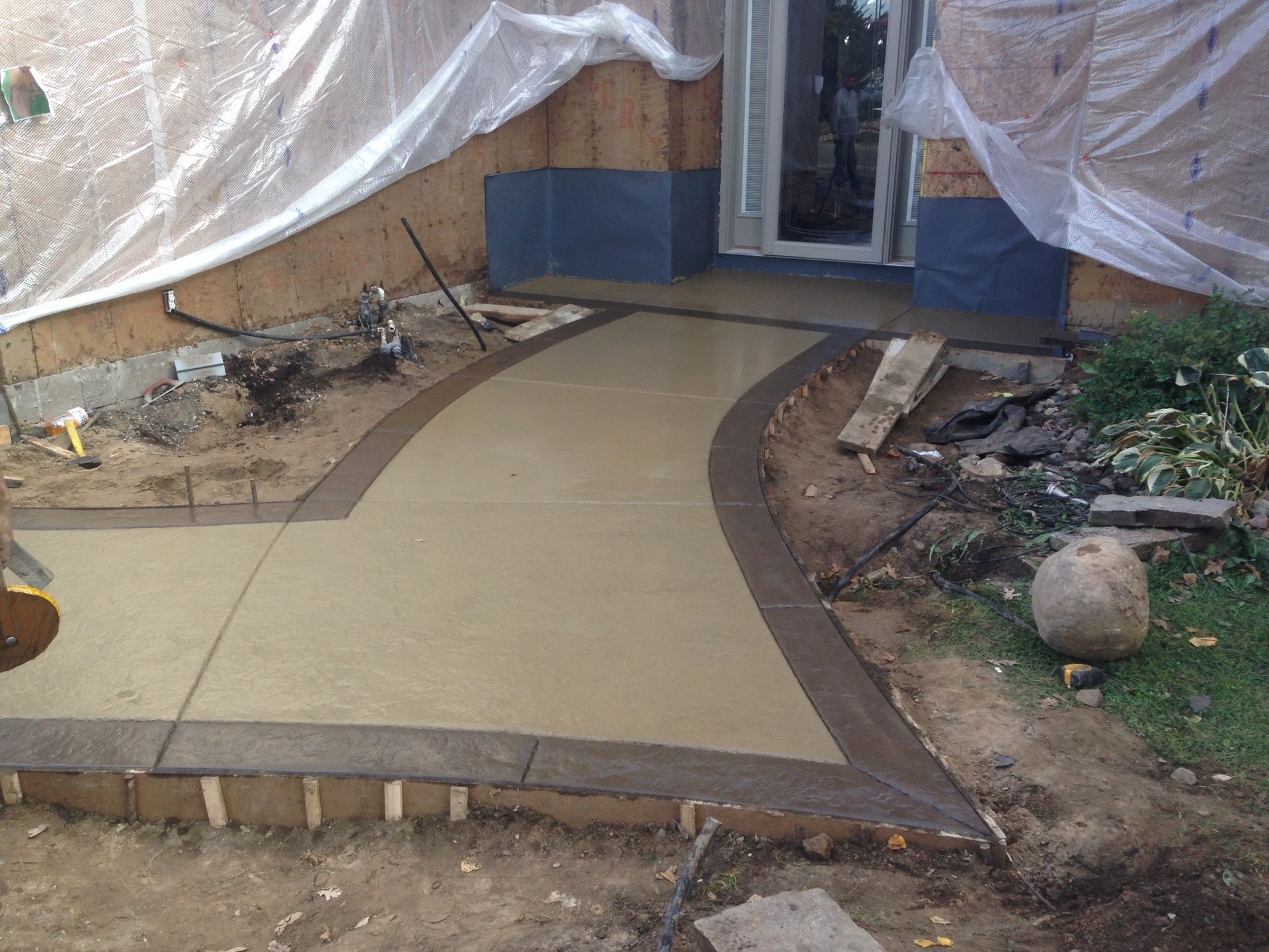 Concrete patio with gray and black stone-like pattern.