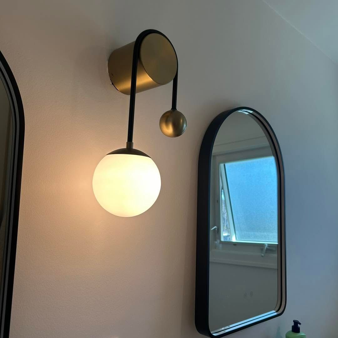 Worker installing a rectangular ceiling light in a modern office space