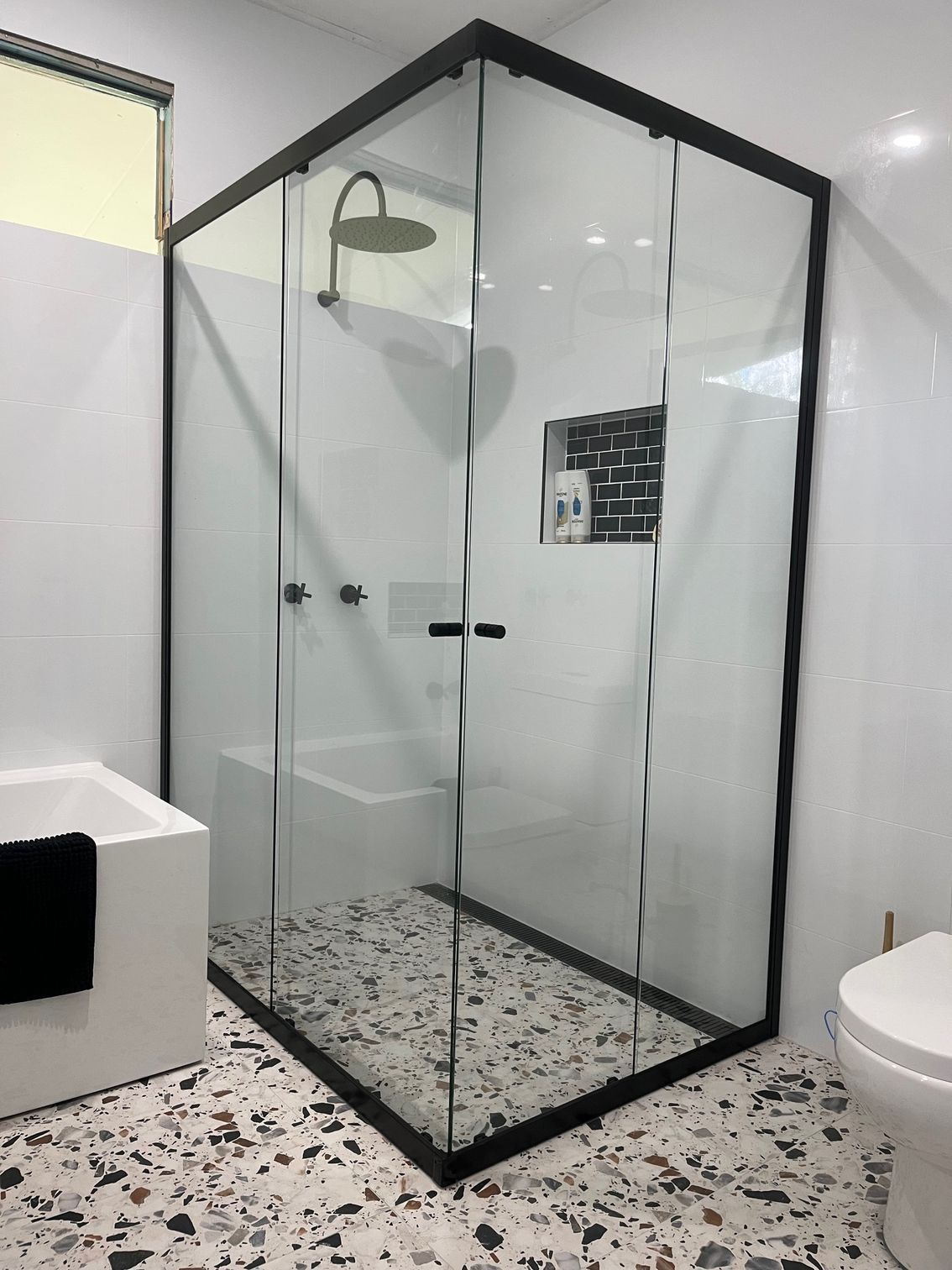 A bathroom with a shower stall, bathtub, toilet and terrazzo floor — Avoca Beach Glass In West Gosford, NSW