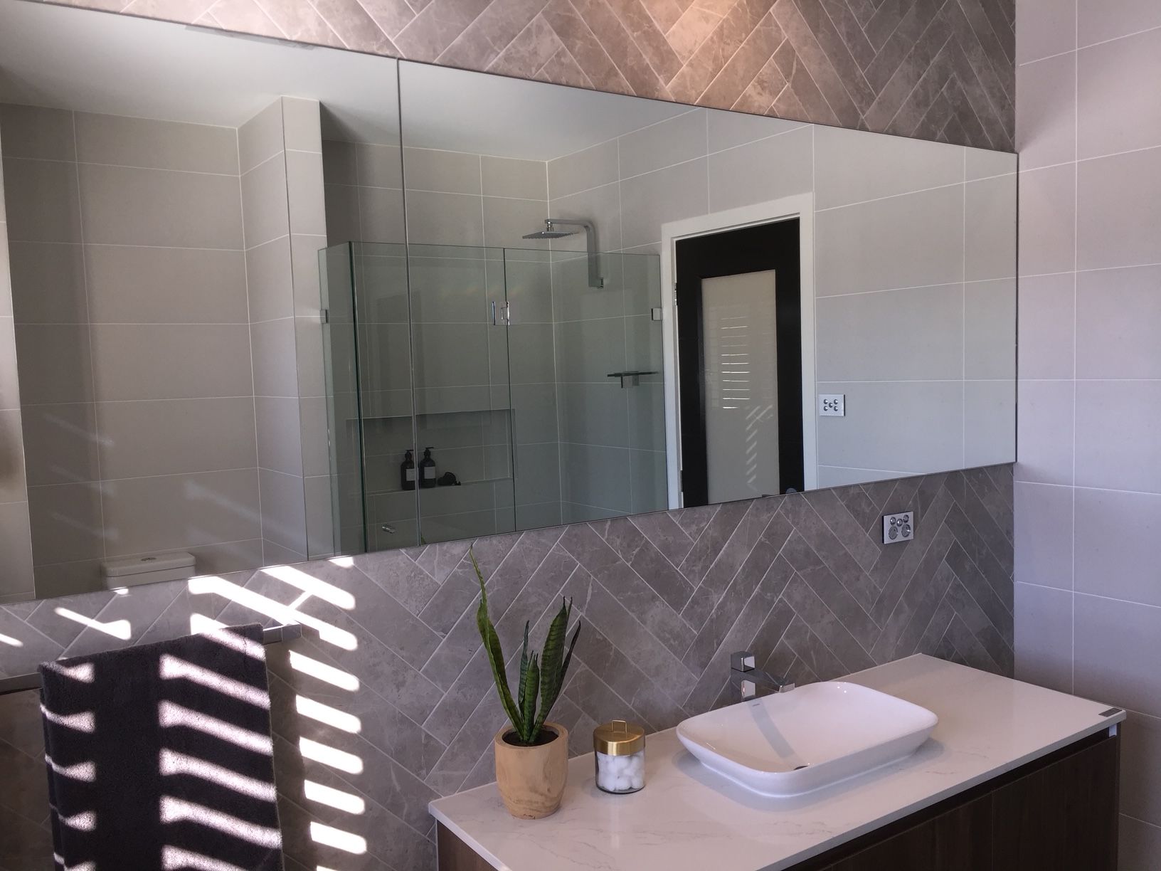 A bathroom with a sink and a large mirror — Avoca Beach Glass In West Gosford, NSW