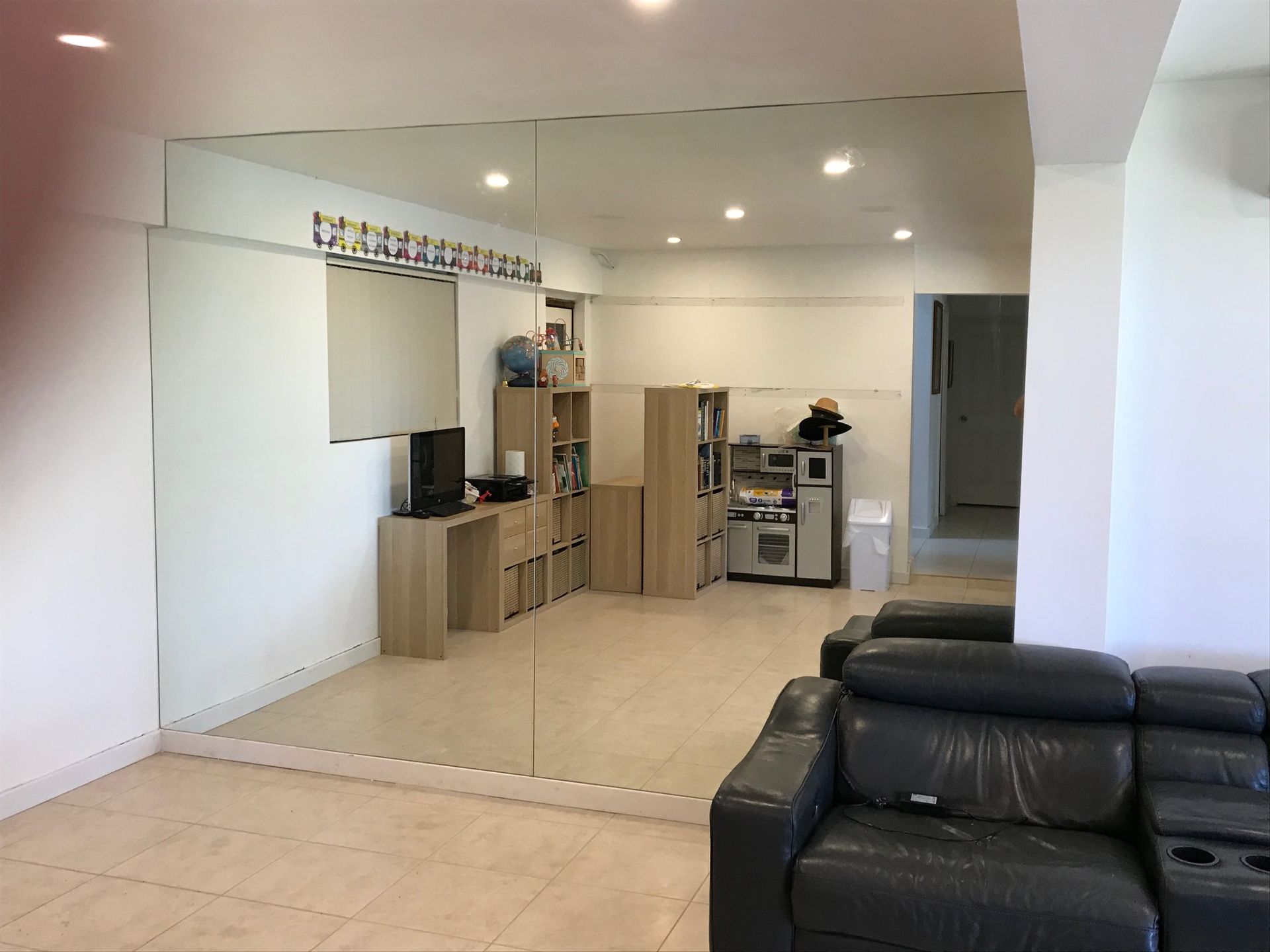 A living room with a large mirror on the wall and a couch — Avoca Beach Glass In West Gosford, NSW