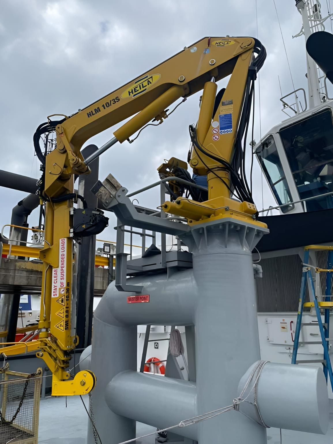 A Large Yellow Crane Is Sitting On Top Of A Large Pipe — Mackay Hose Fitting Services In West Mackay, QLD