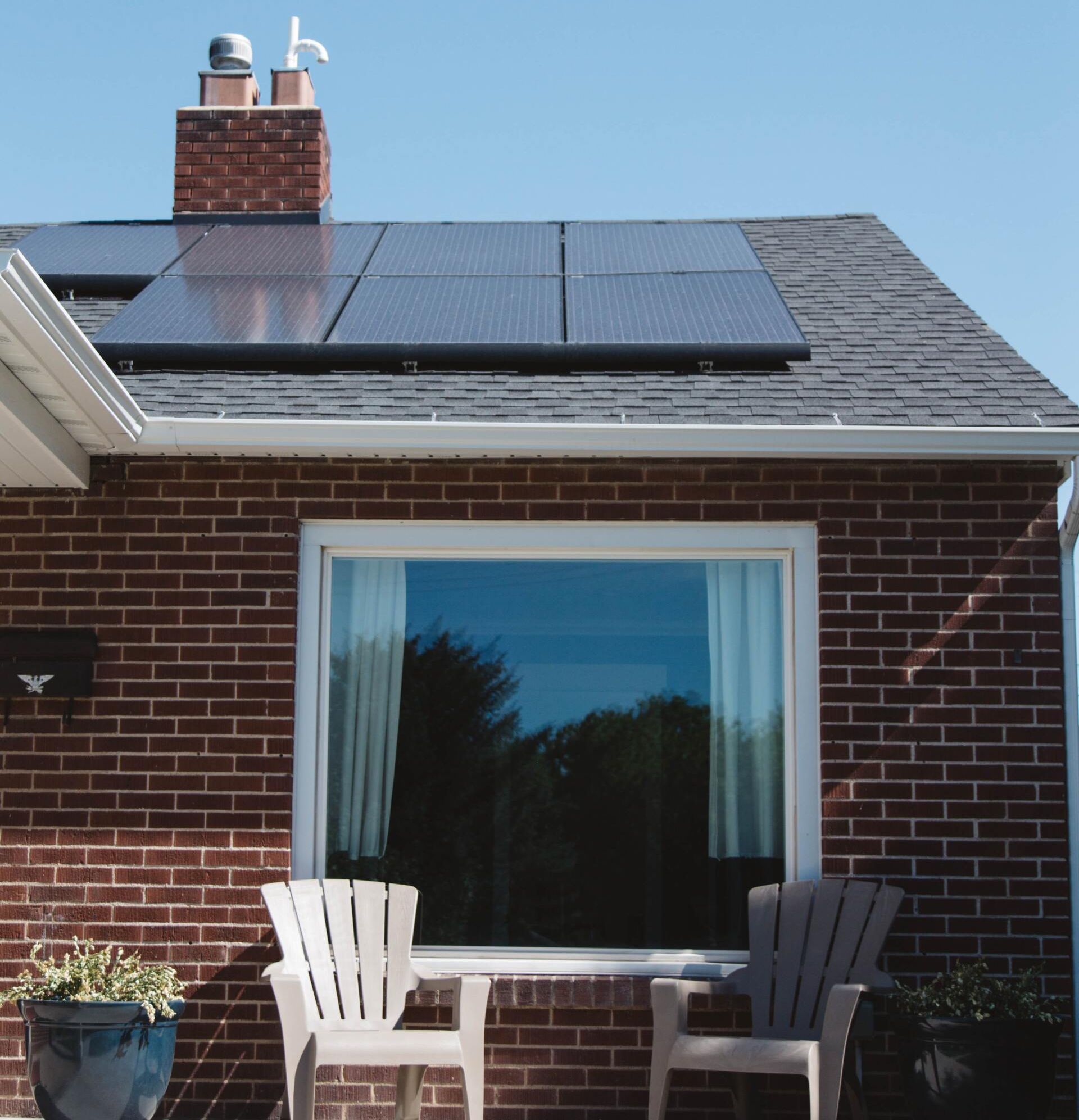 Newly installed solar panel gleaming on the rooftop of a residential house.