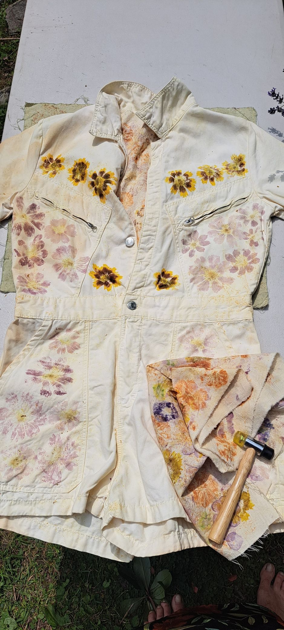A light-colored floral-dyed shirt and shorts set, spread out on a white surface.