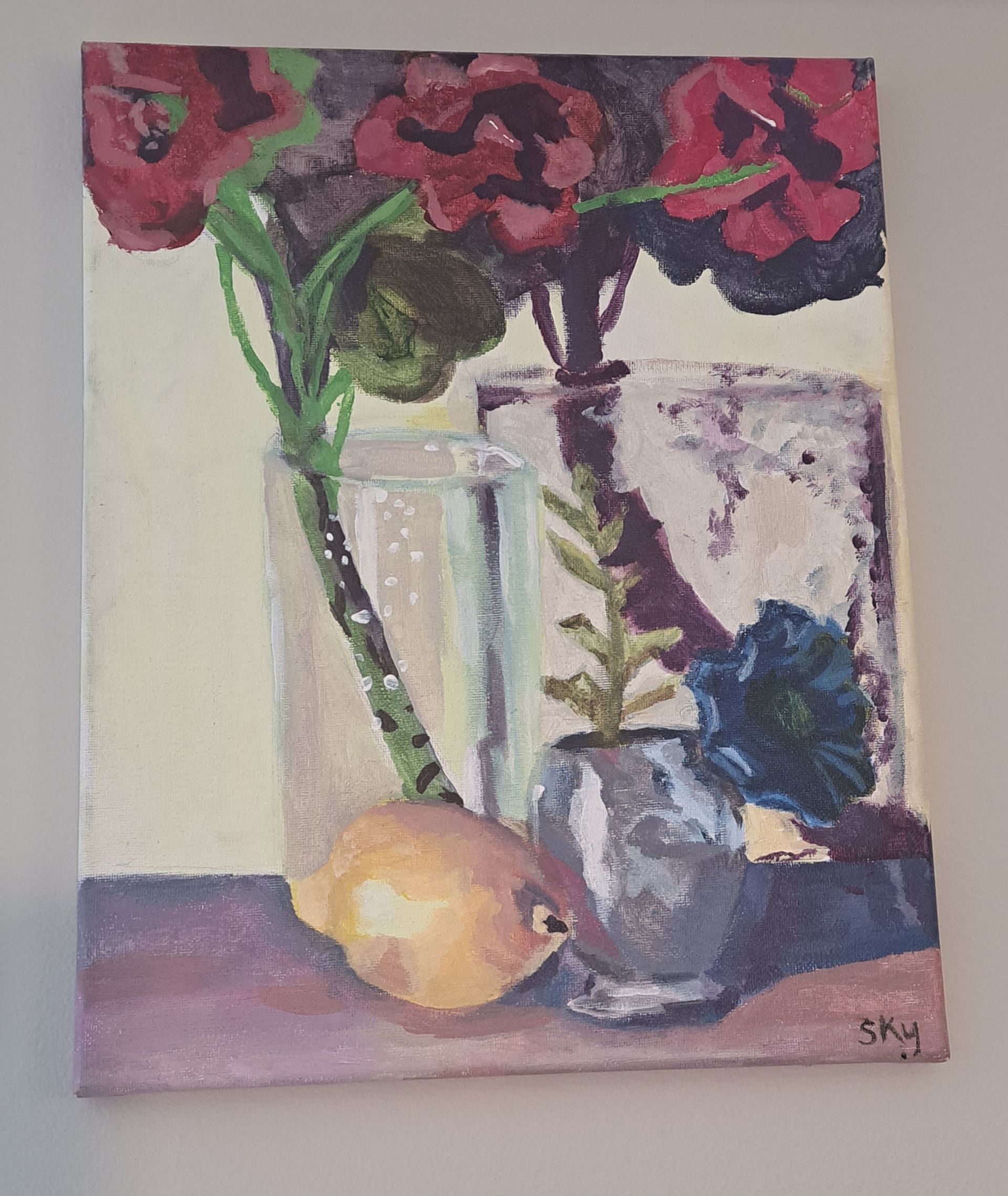 Still life painting of flowers, a lemon, and vases in muted reds, greens, blues and yellows.