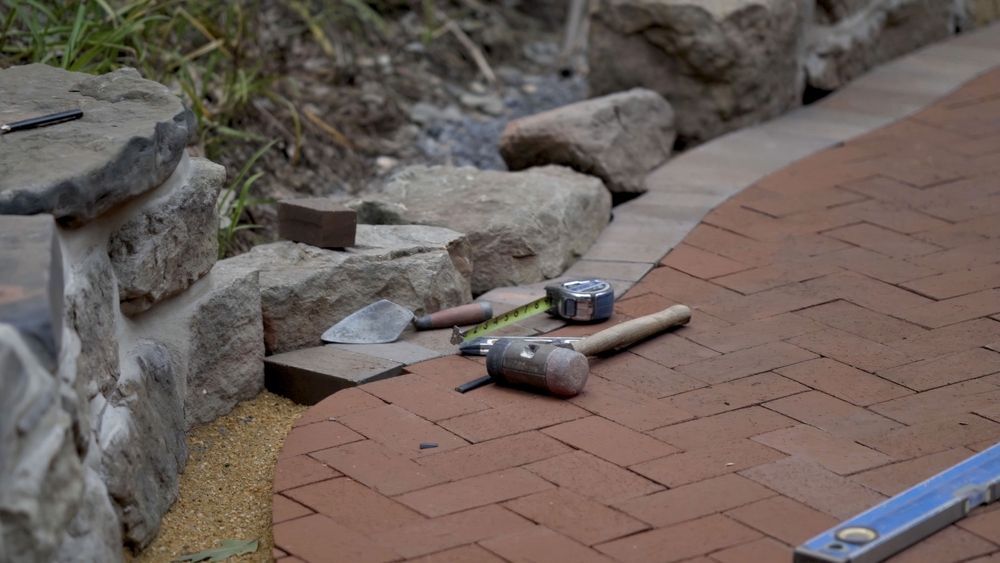 A brick walkway with tools and a level on it.