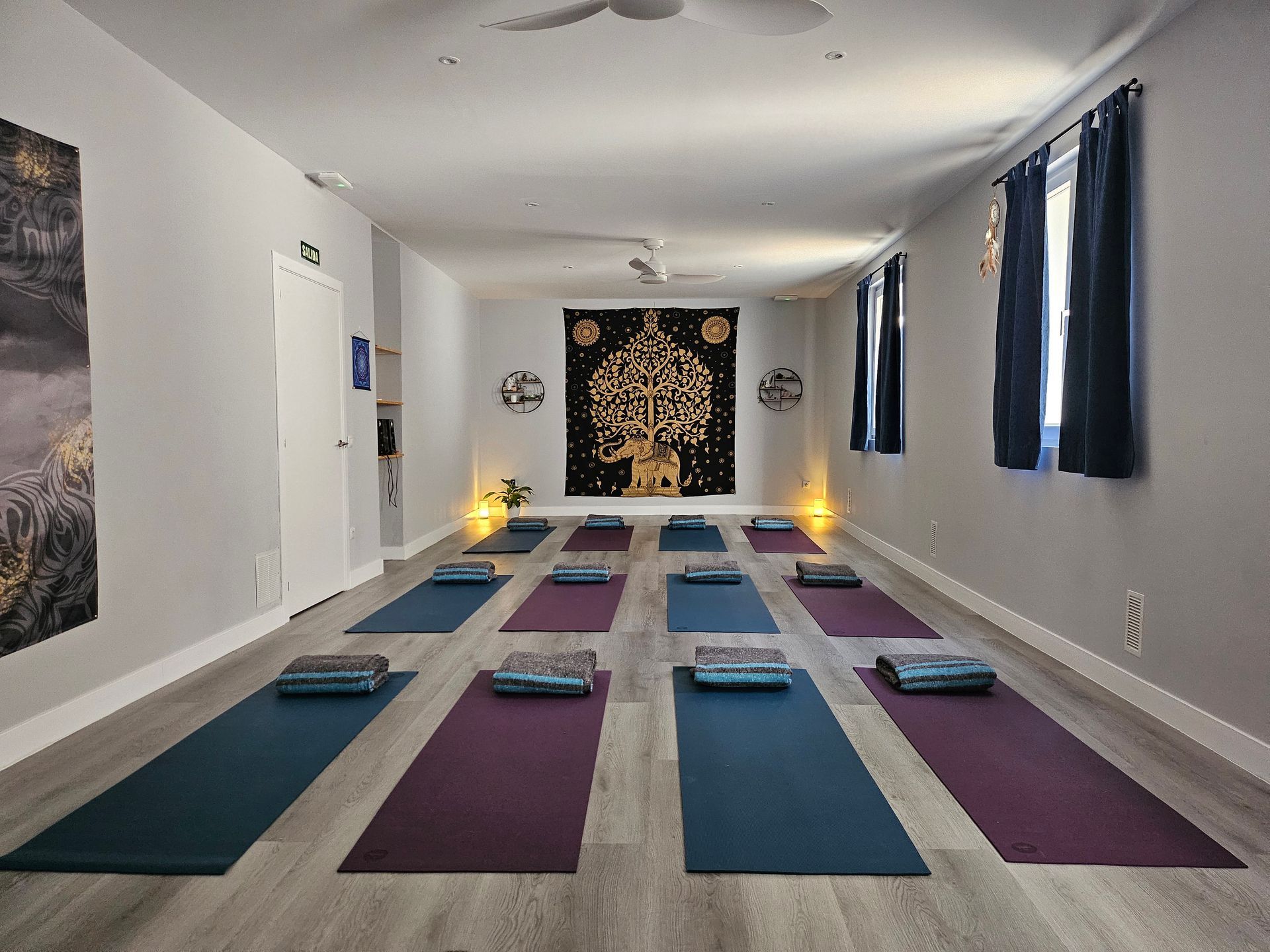 Una habitación llena de colchonetas de yoga y almohadas en el suelo.