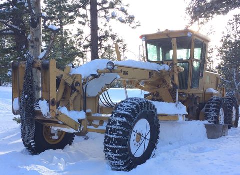 Snow Removal — Grader Plowing Snow Off the Gravel Roads in Weston, CO