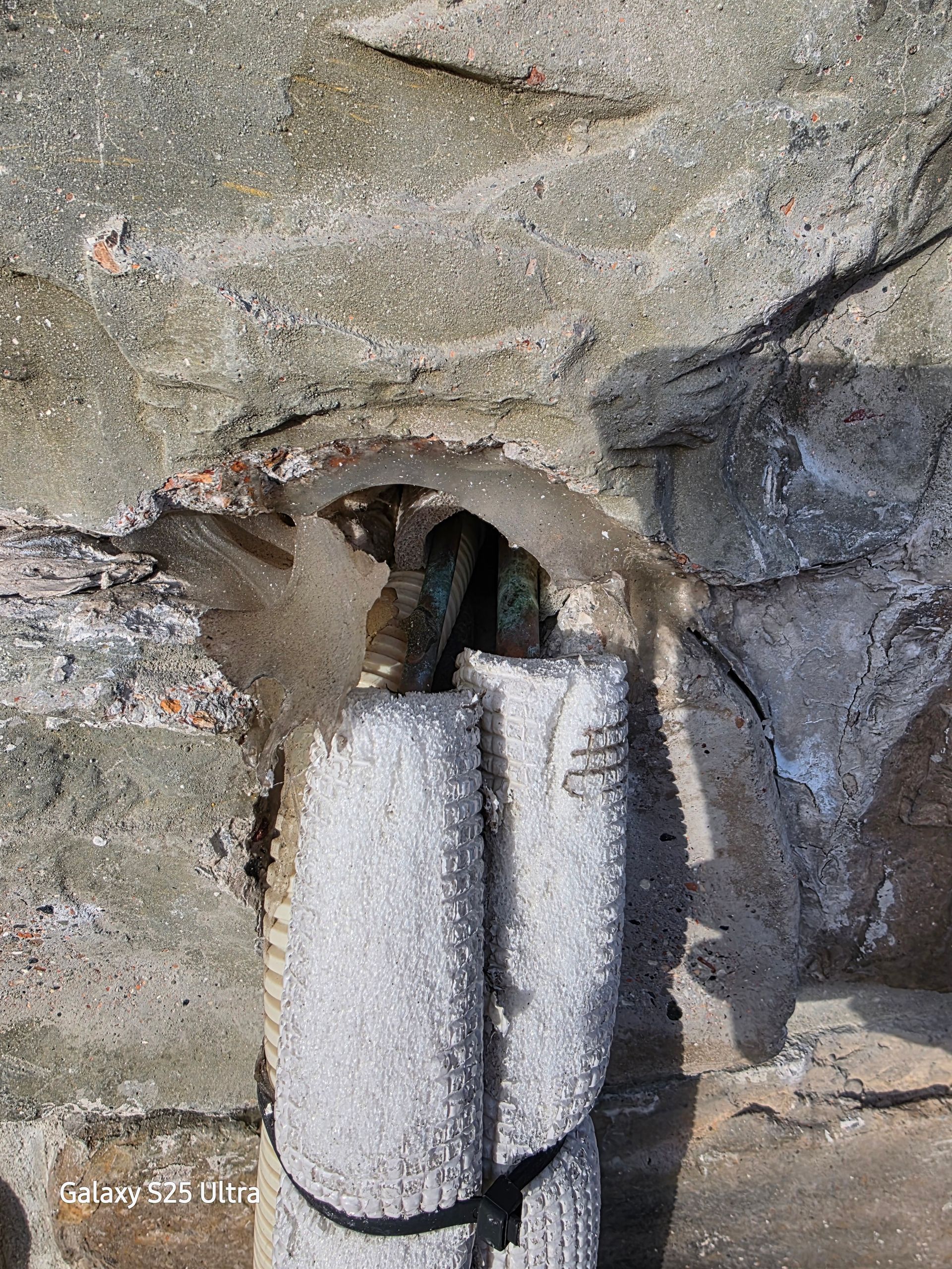 Stone column with weathered texture inside a stone alcove.