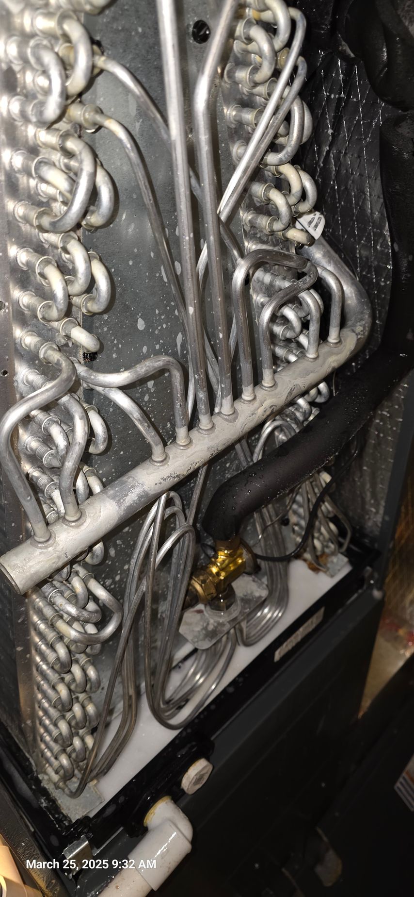 Air conditioner coils with condensation and a drain pipe.