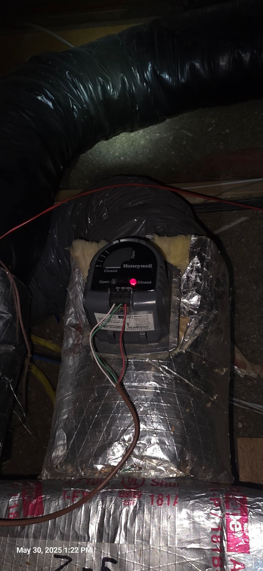 HVAC unit in an attic with ductwork, electrical wiring and a digital display.