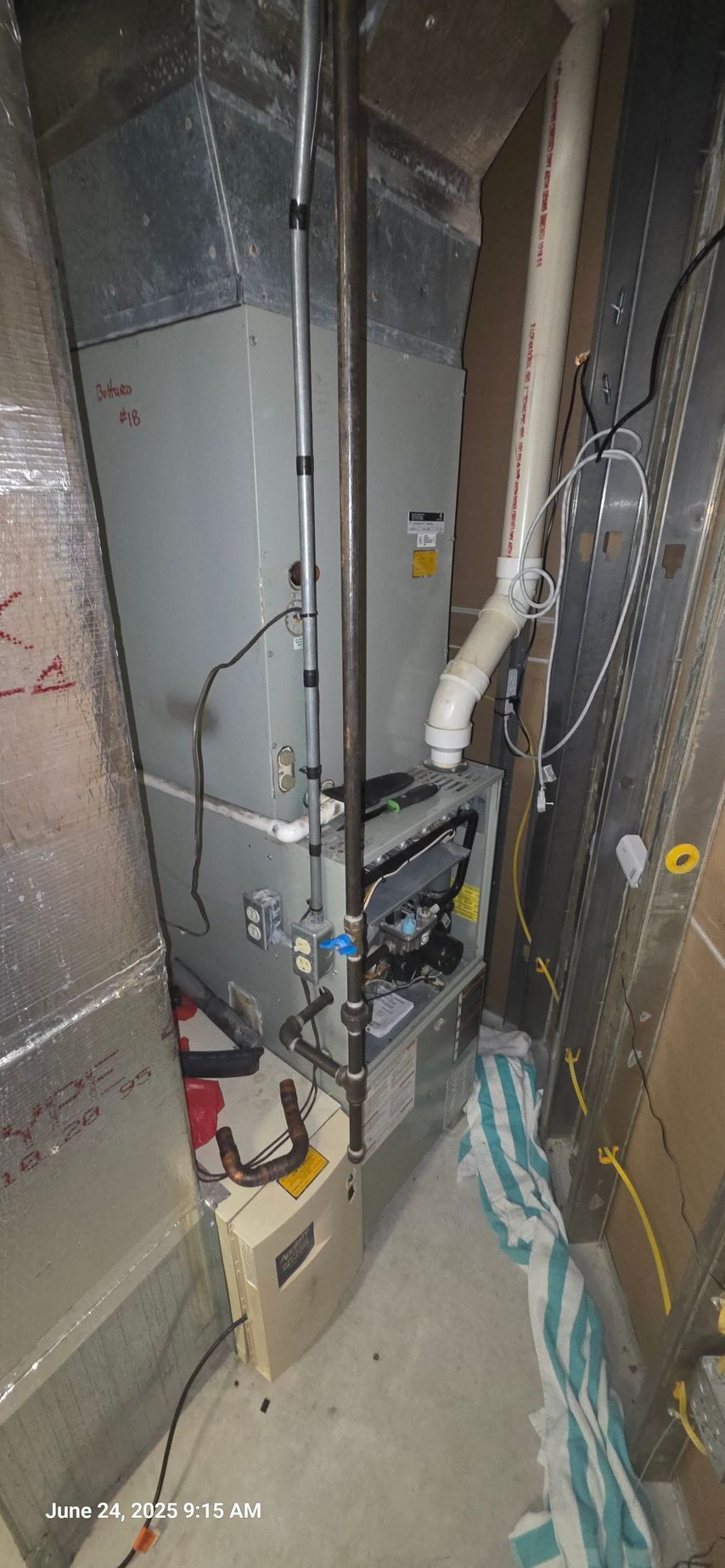 Furnace in a utility room with ductwork and a water pipe.