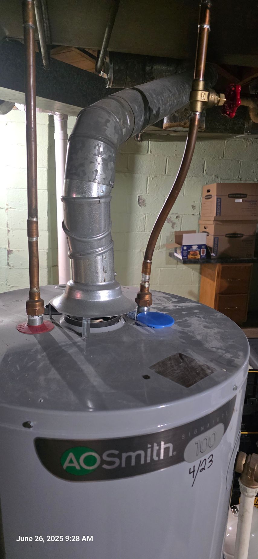 An AO Smith water heater with copper pipes in a basement.