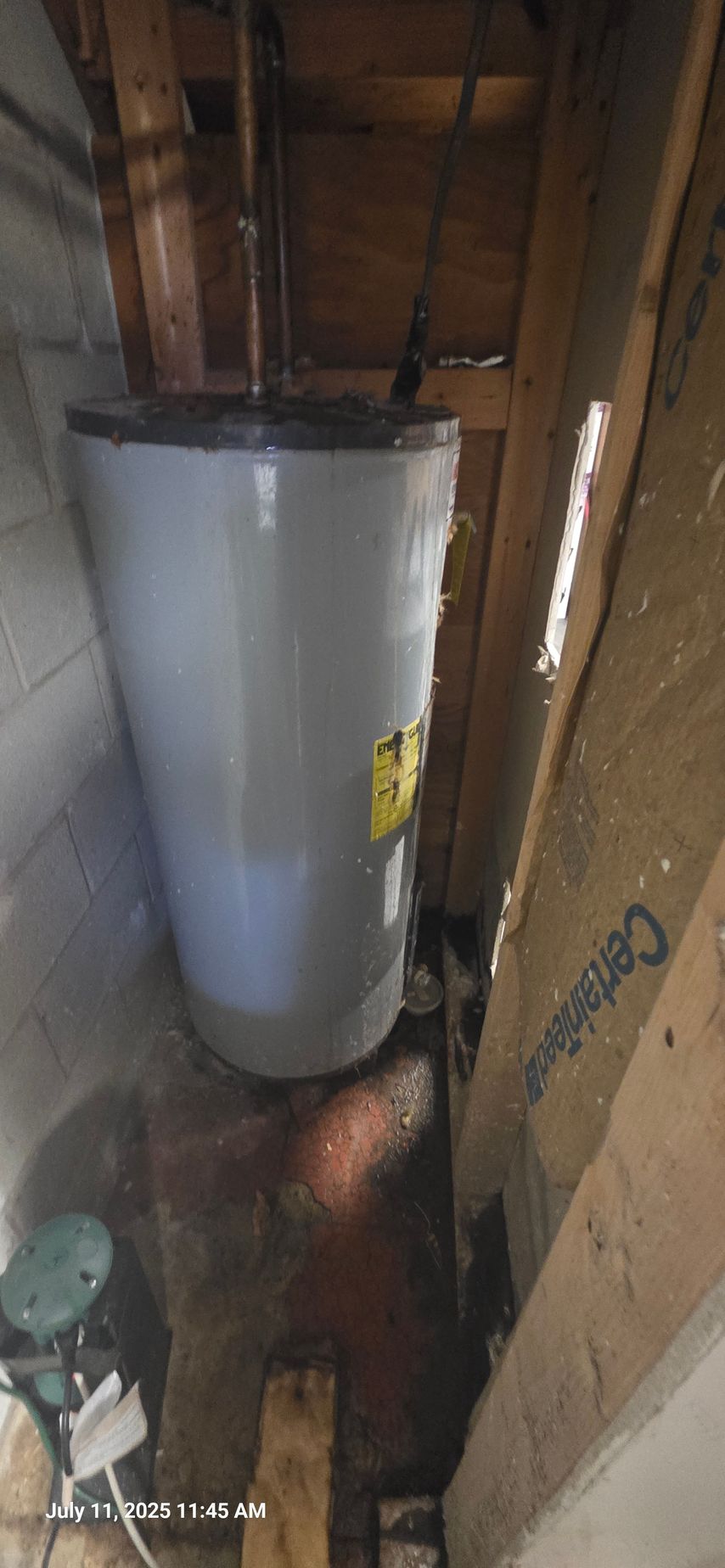 Water heater in a cramped, unfinished space with potential water damage.