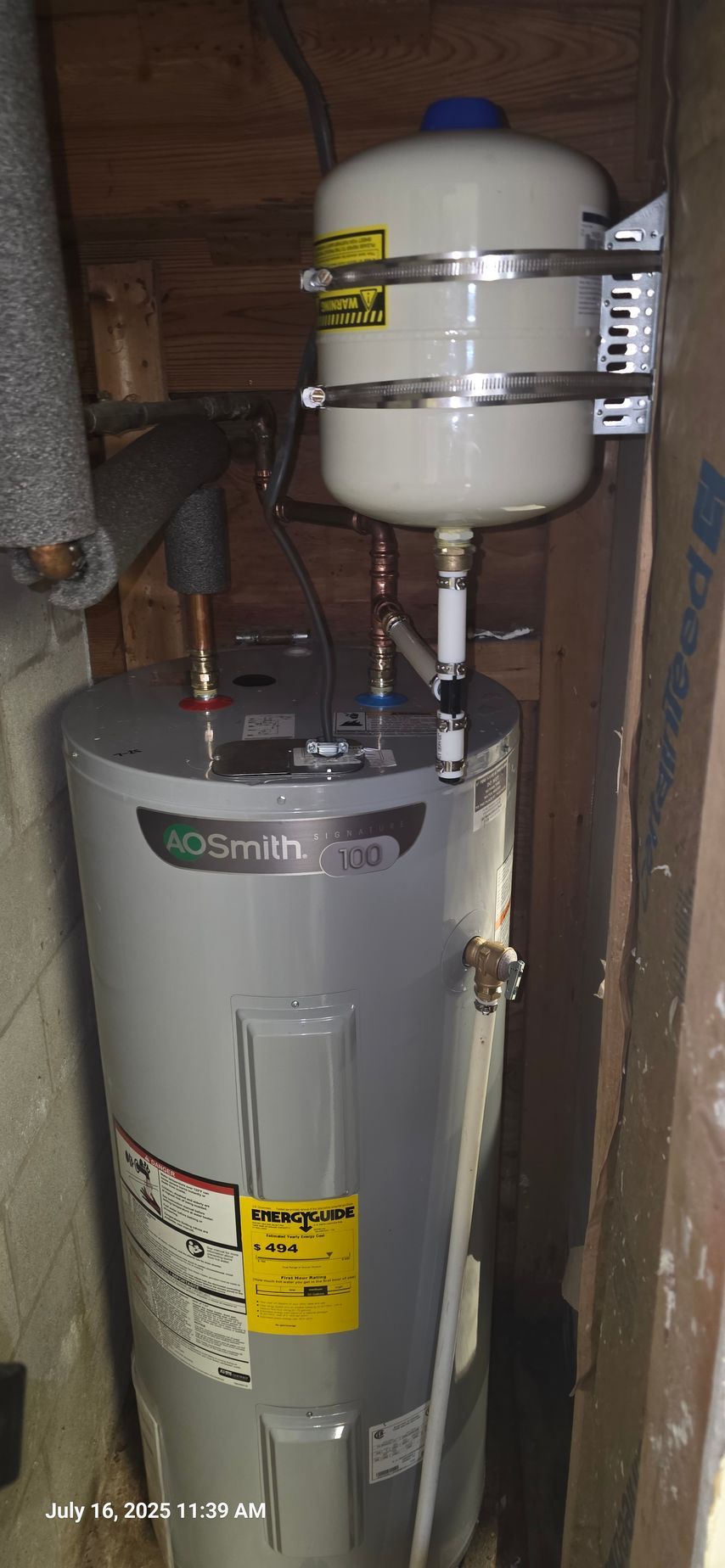 Water heater with expansion tank in a utility closet.