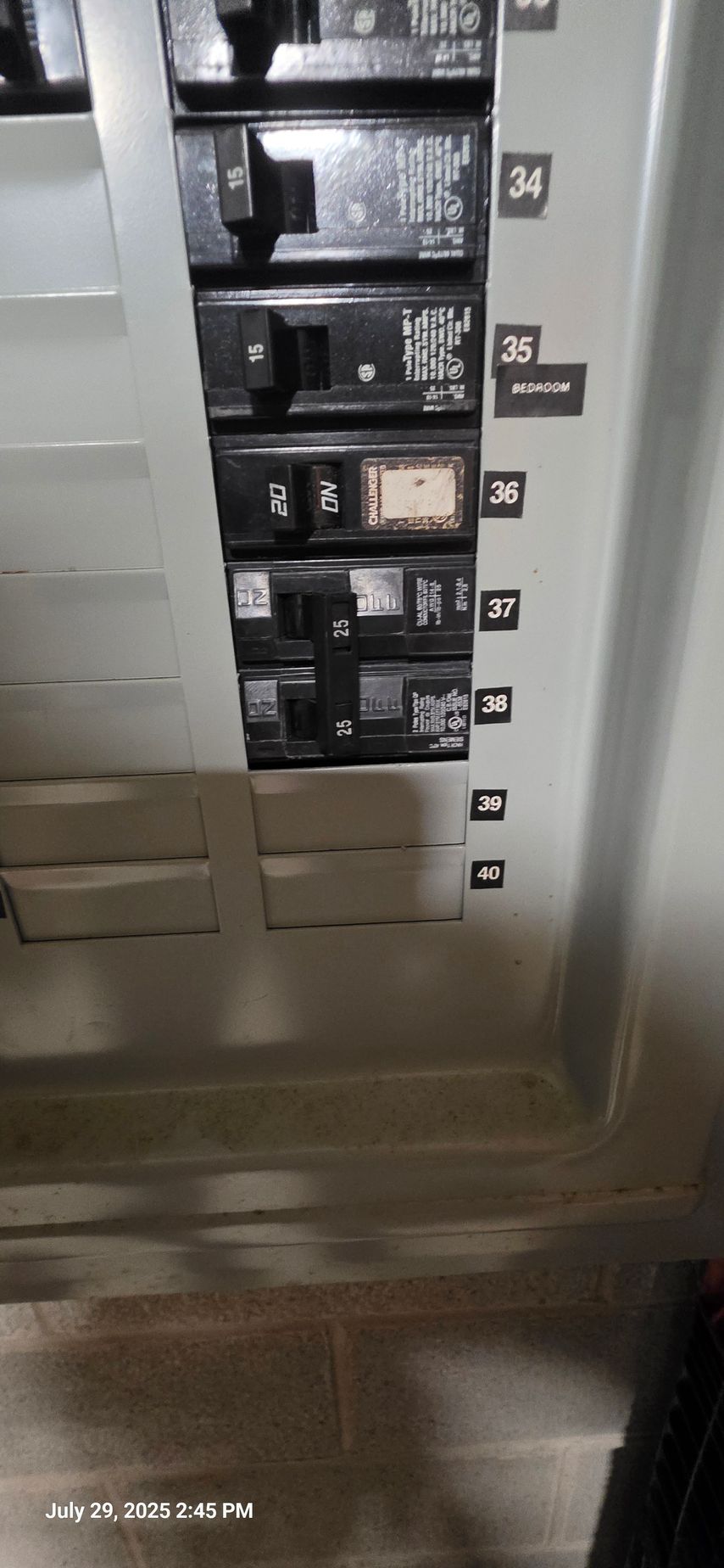 Electrical circuit breaker panel with several breakers in the on and off positions, indoors.