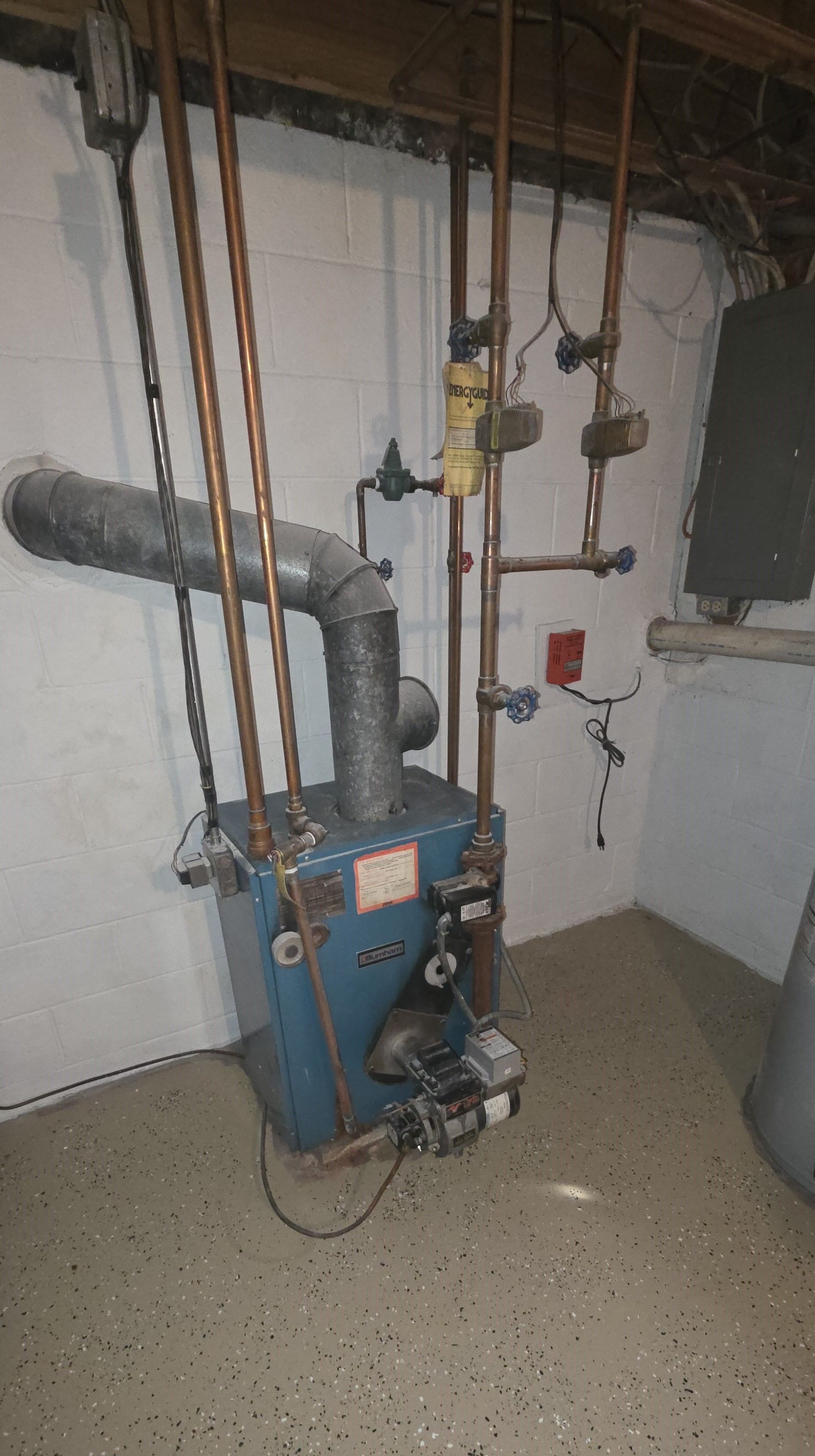 Blue furnace with copper pipes in a basement.
