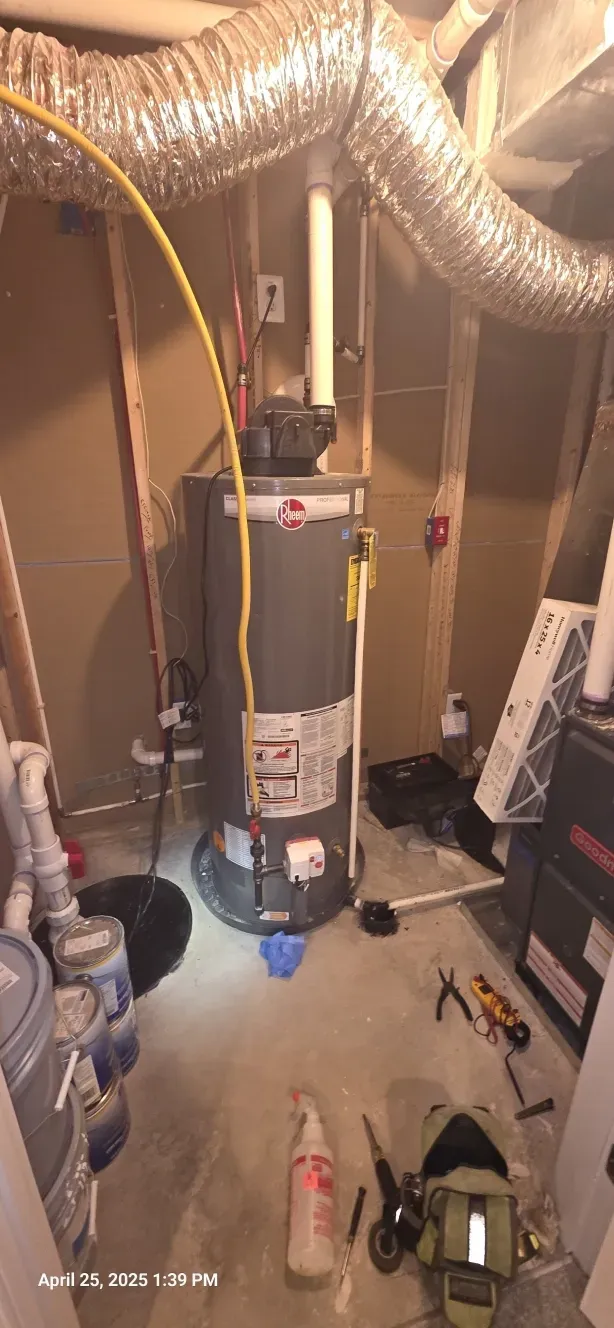 A basement with a water heater, ductwork, and tools.
